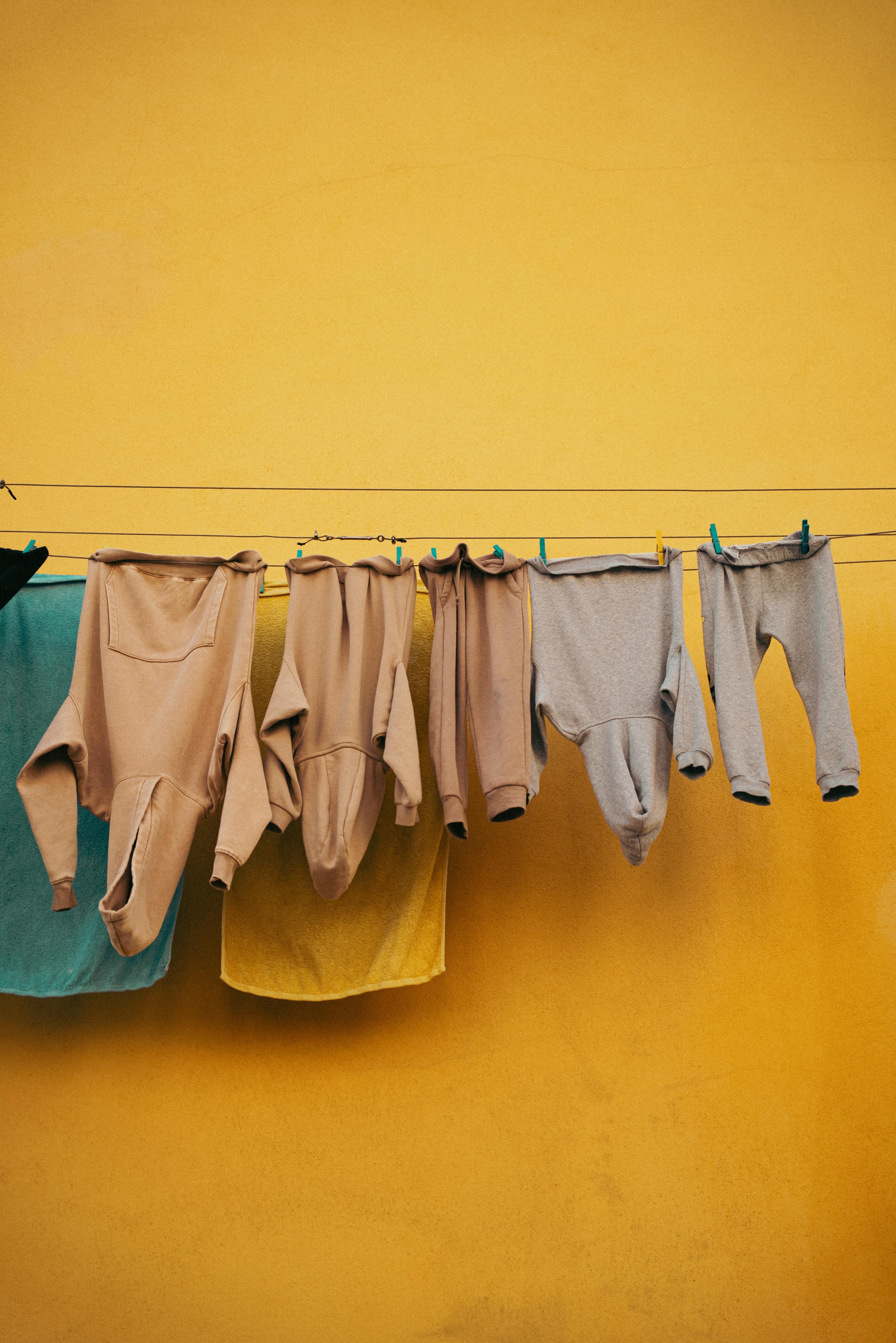 Clothes hanging in front of yellow wall