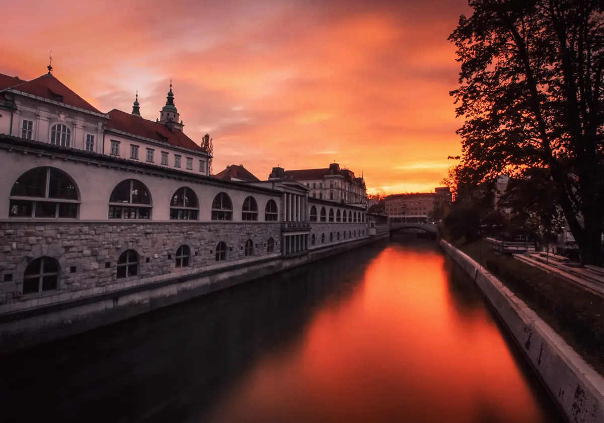 Golden sunset reflecting in Ljubljanica river in Ljubljana city center, Slovenia.