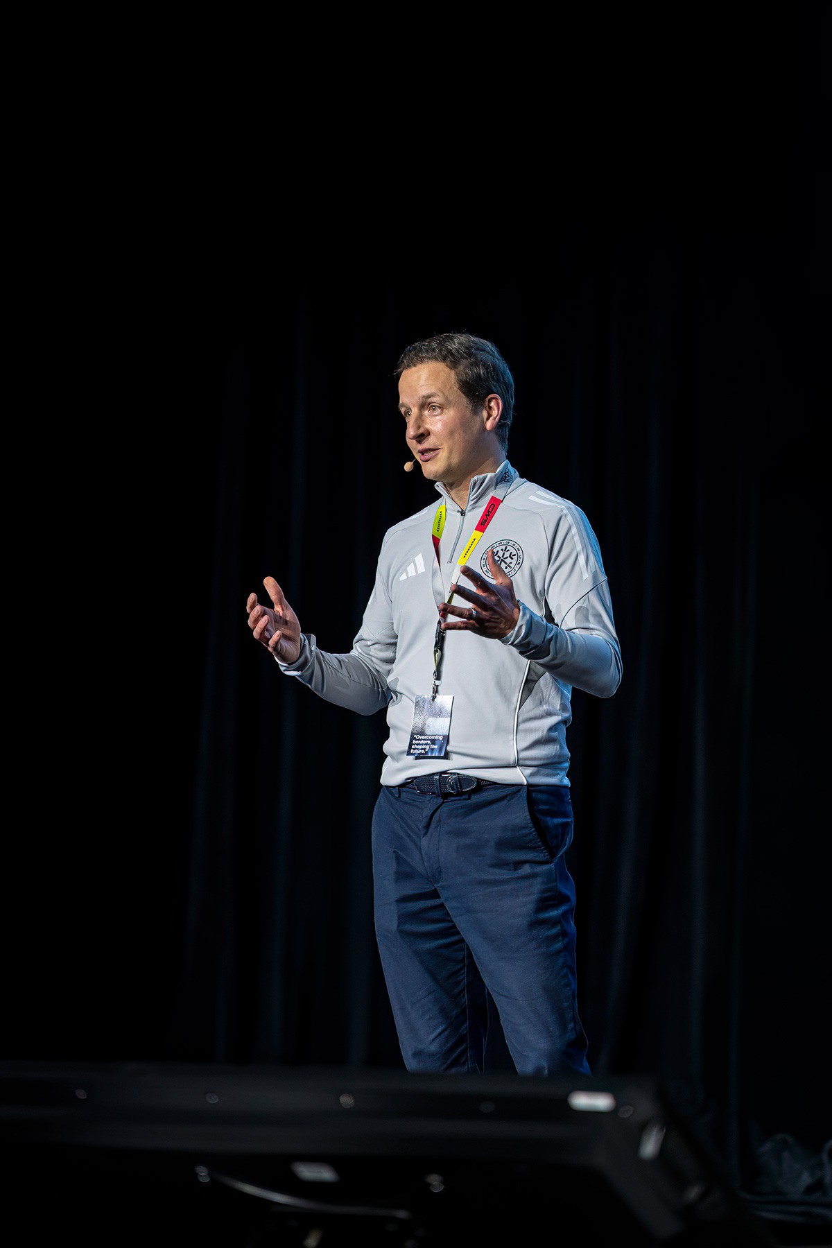 Keynote speaker presenting on stage during a professional business conference.