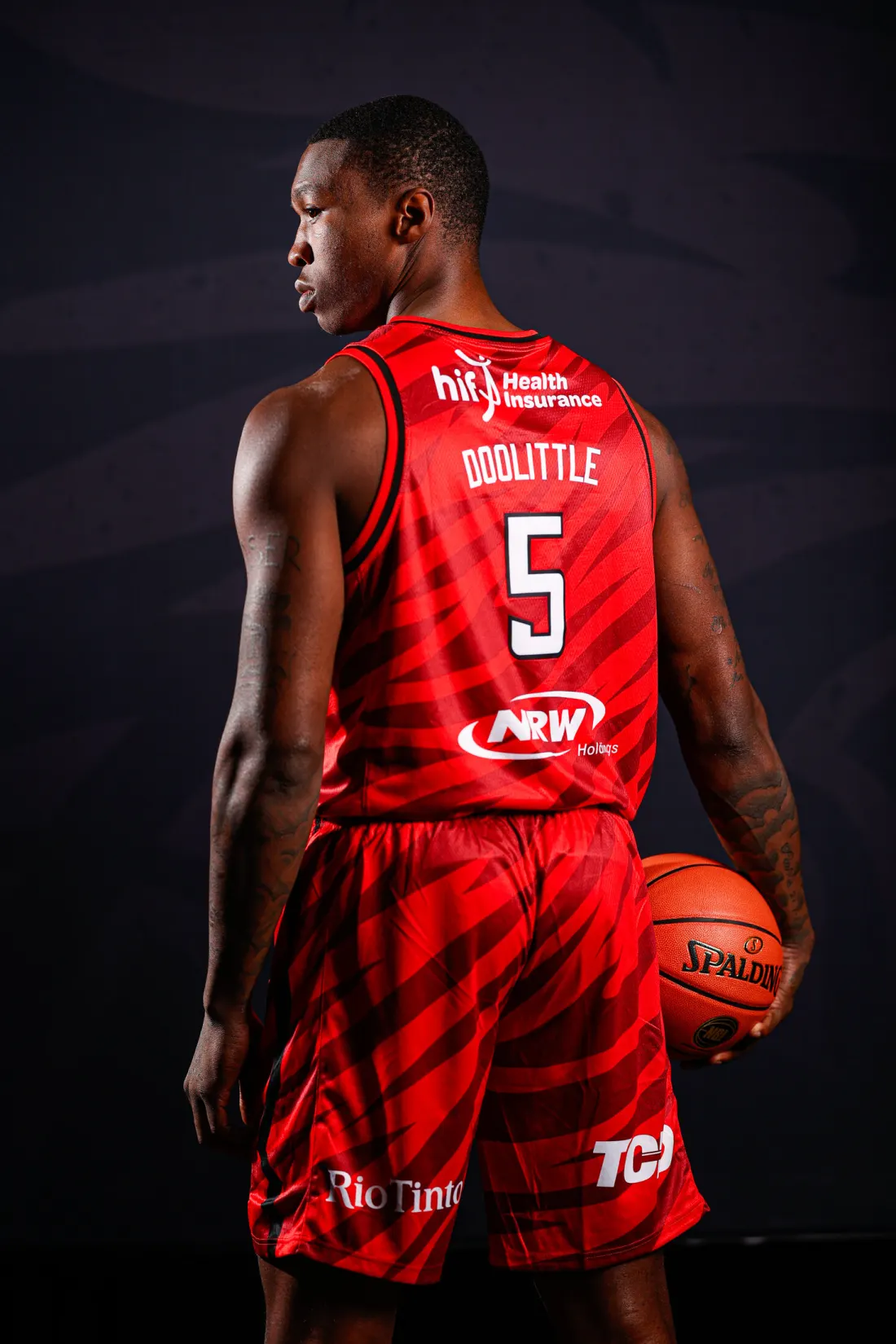 Perth Wildcats player wearing the redesigned red playing strip and holding a basketball