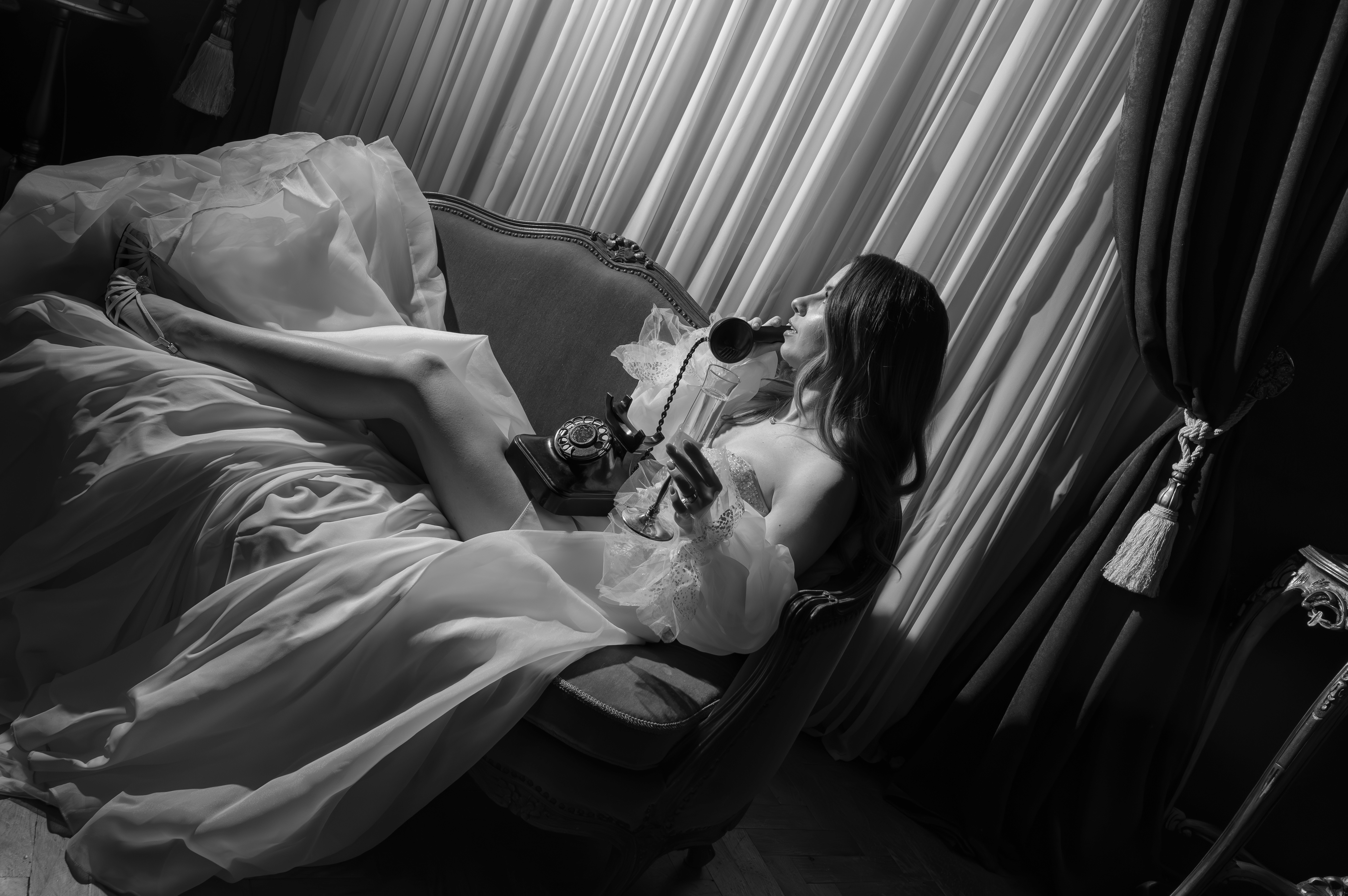 Fotografie alb-negru mireasă pe fotoliu, rochie elegantă, atmosferă cinematografică nuntă