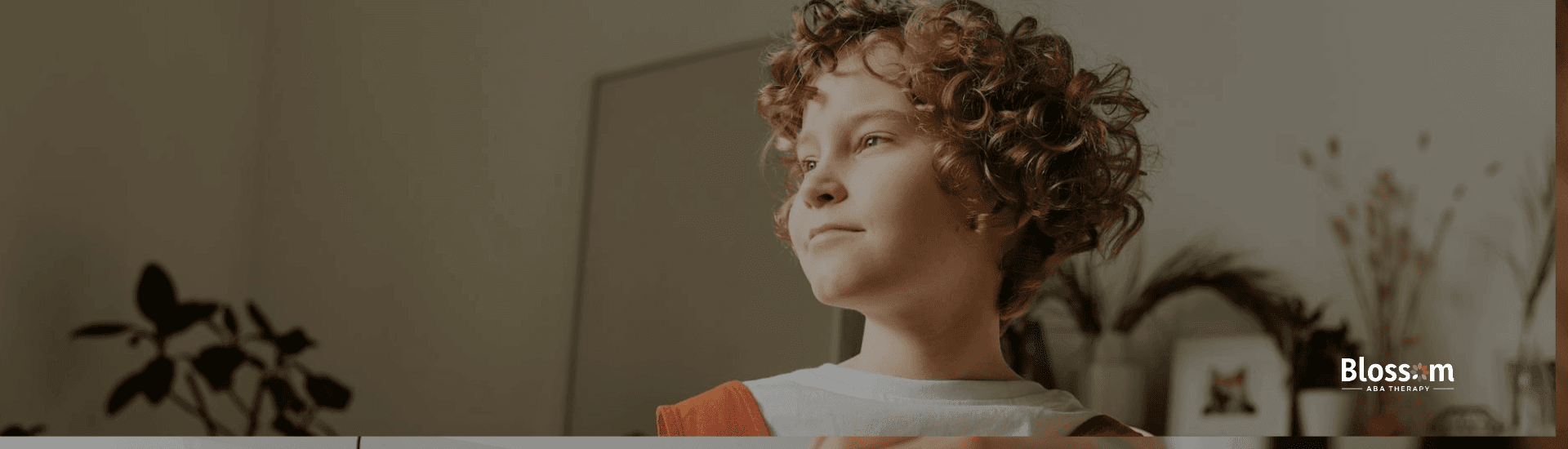 A confident autistic young girl holding a tablet, looking out the window After ABA therapy in Nebraska.