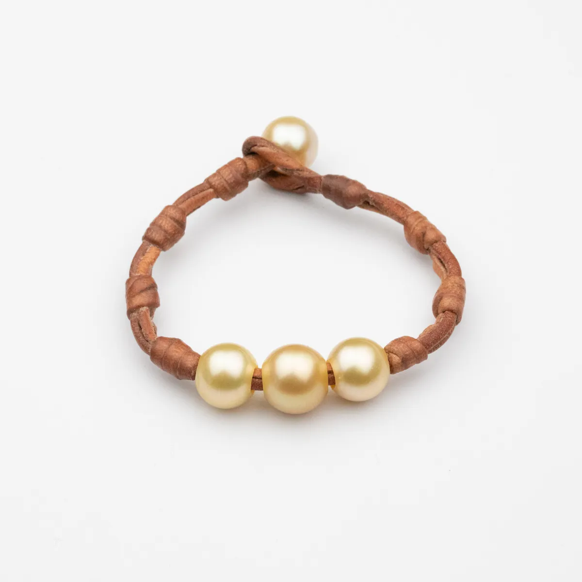 Four round golden South Sea Pearls on wrapped natural leather cord bracelet with pearl toggle closure — Manos de Oro Saint Barth