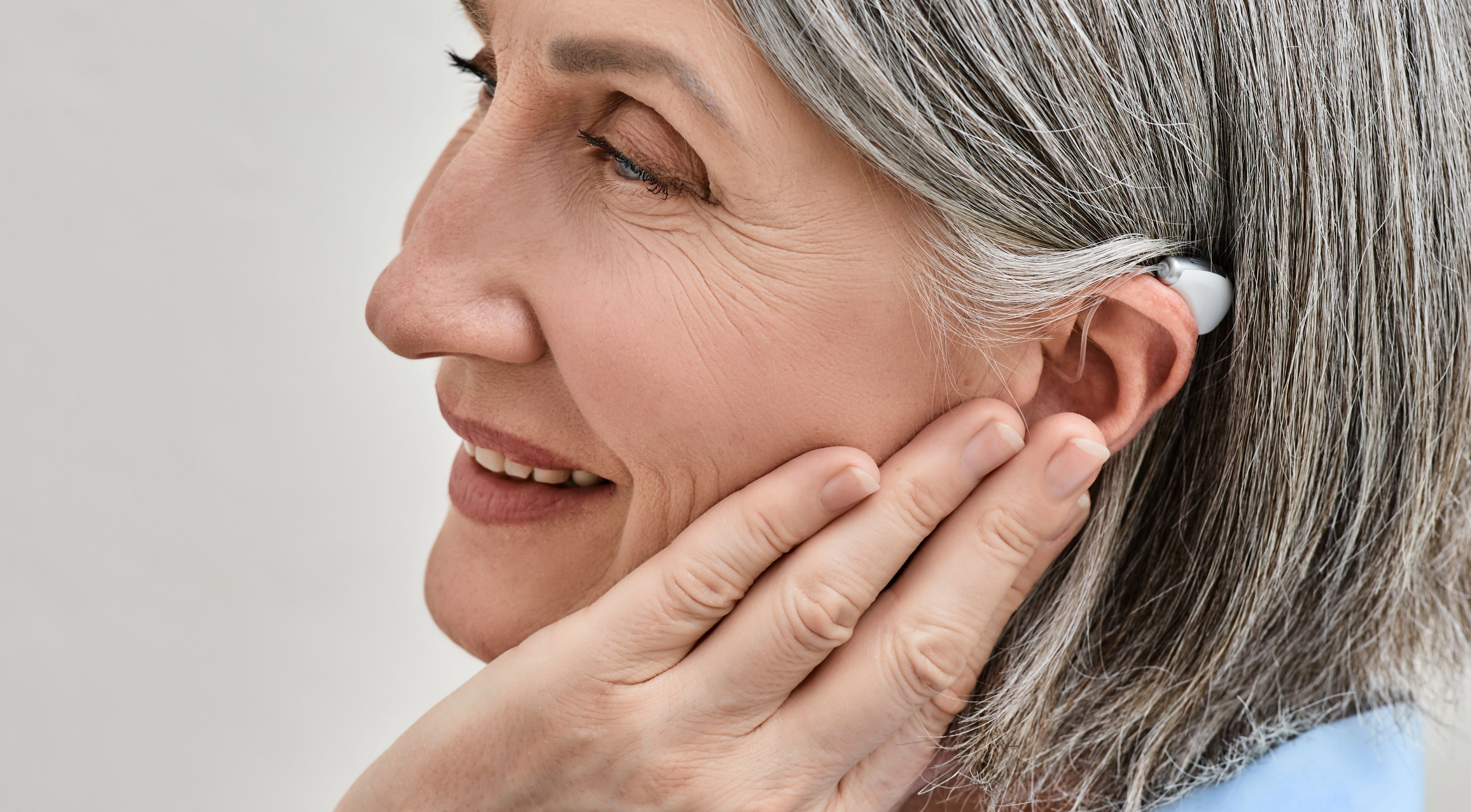 Fran, jefe de proyectos, colocándose un audífono con gesto serio y profesional