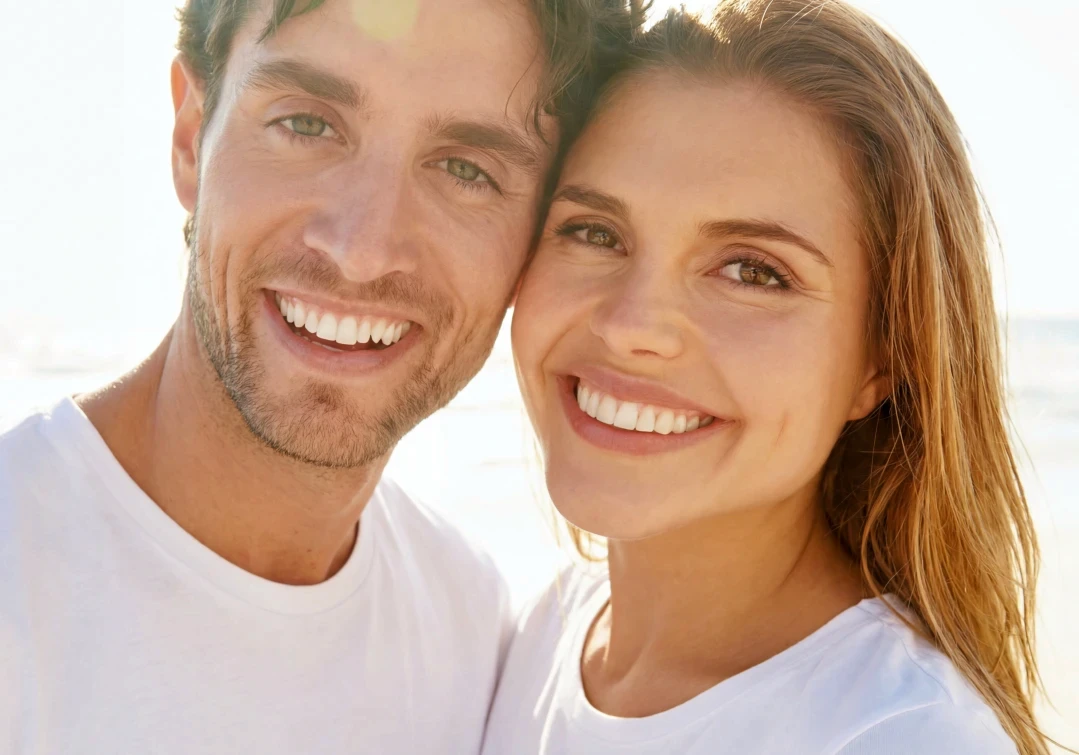 Kobieta z uśmiechem prezentująca efekty bondingu na swoich zębach.