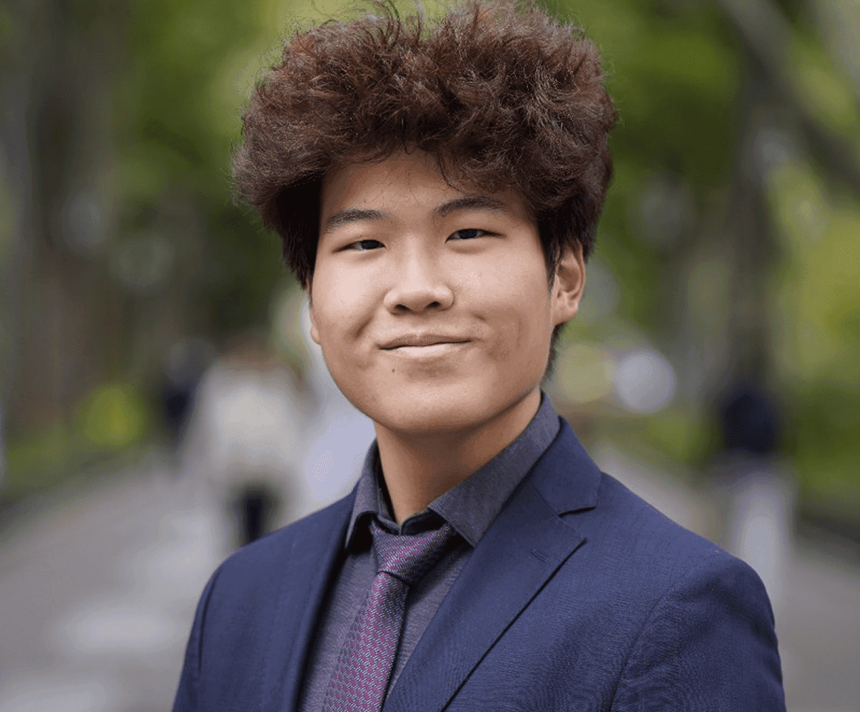 Man in suit with curly hair outdoors