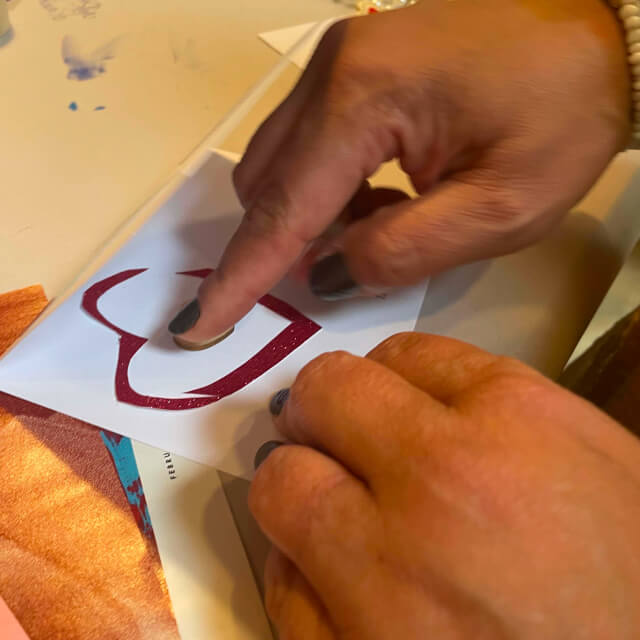 A hand holds a green cup filled with blue shaved ice and a white spoon