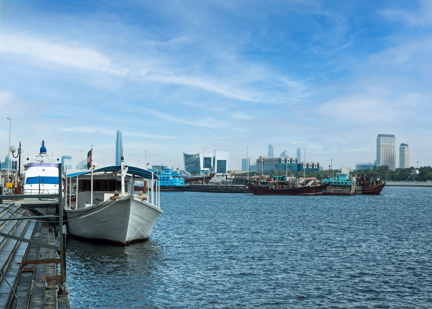 Boats docked near Deira waterfront, with traditional dhows and modern skyline blending heritage and urban development.