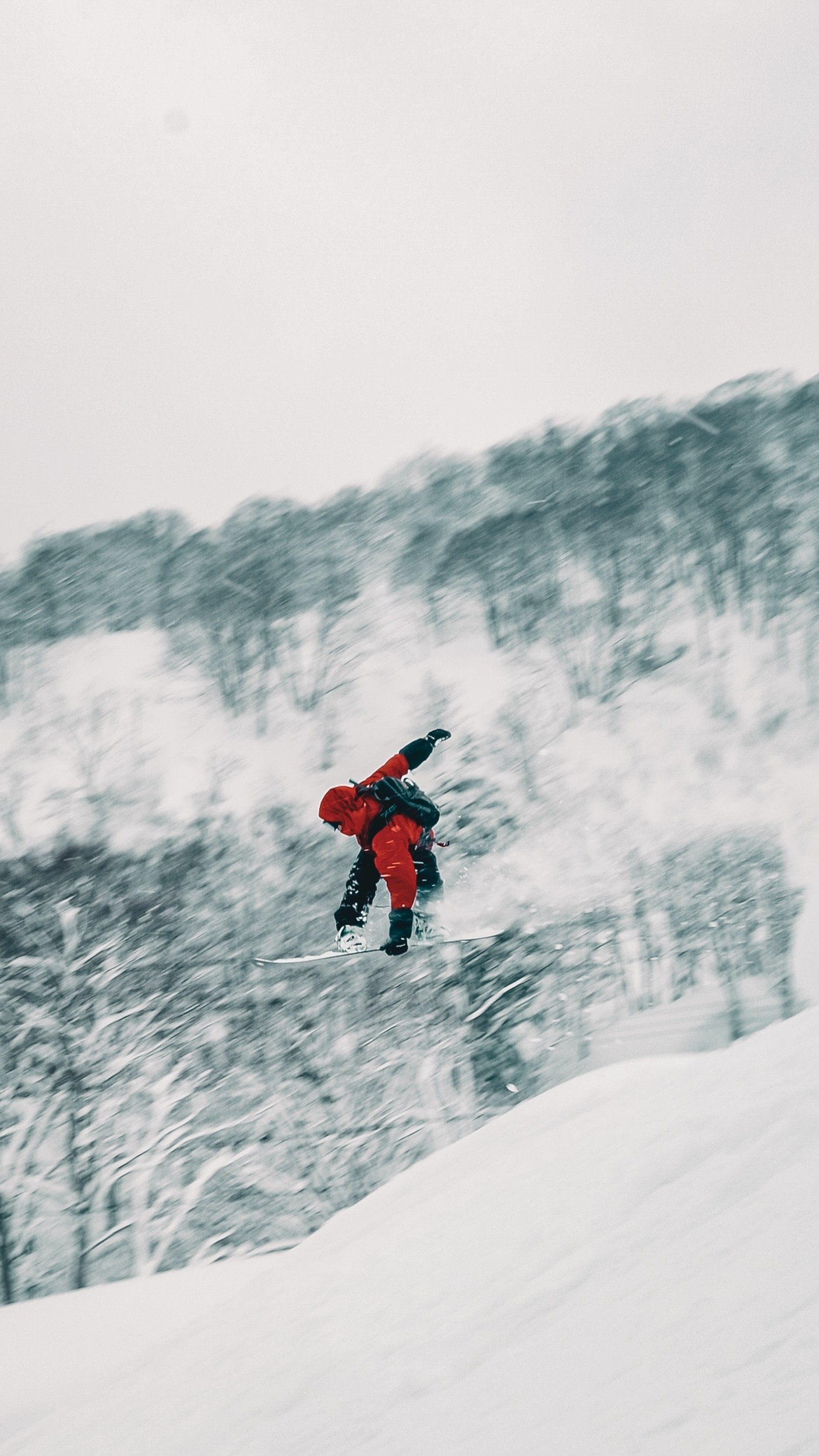 Personne en snowboard descendant une pente enneigée en montagne