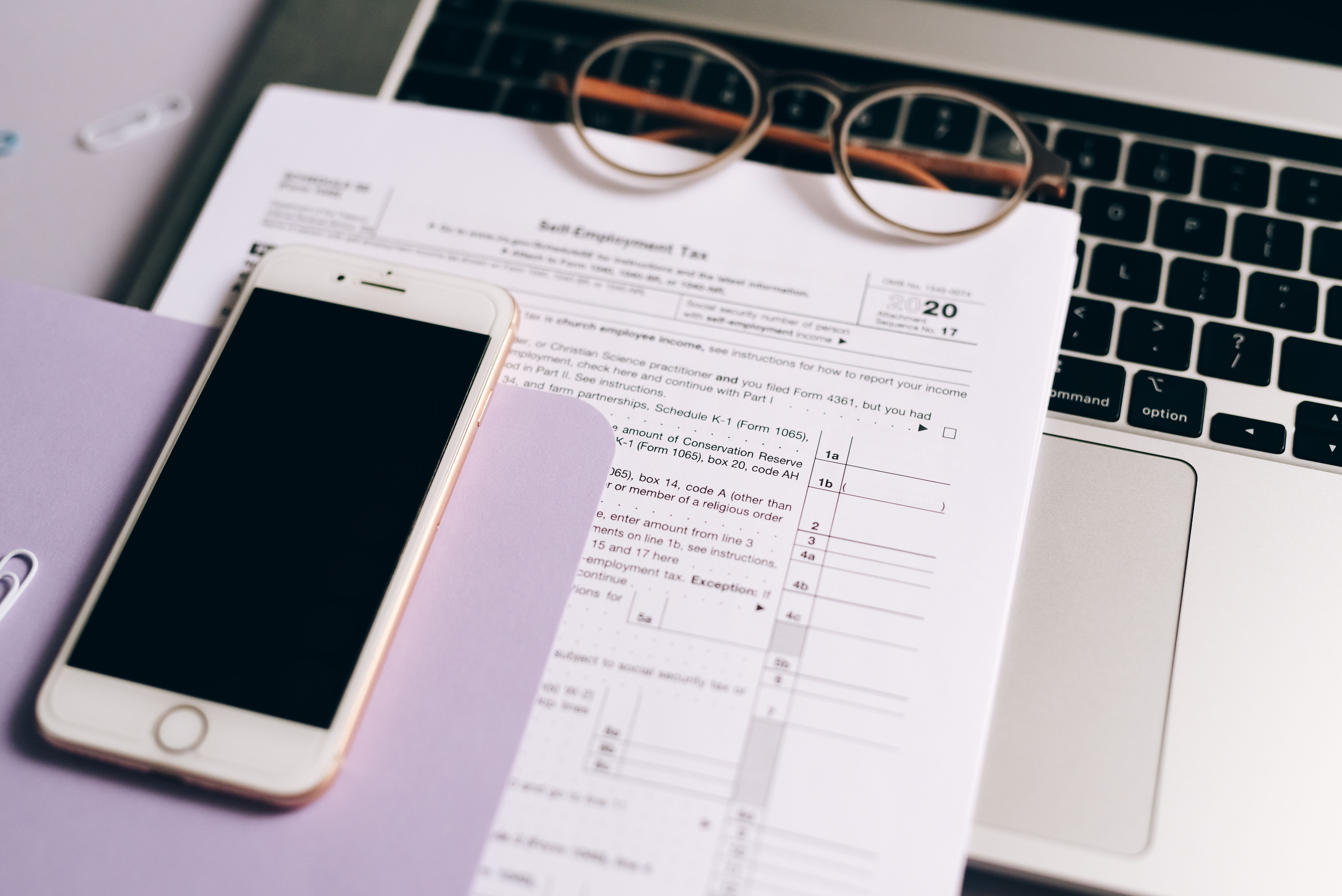 Smartphone cu documente fiscale și laptop pe birou, configurare contabilitate digitală și monitorizare plafoane TVA, casierie și Intrastat pentru SRL 2026