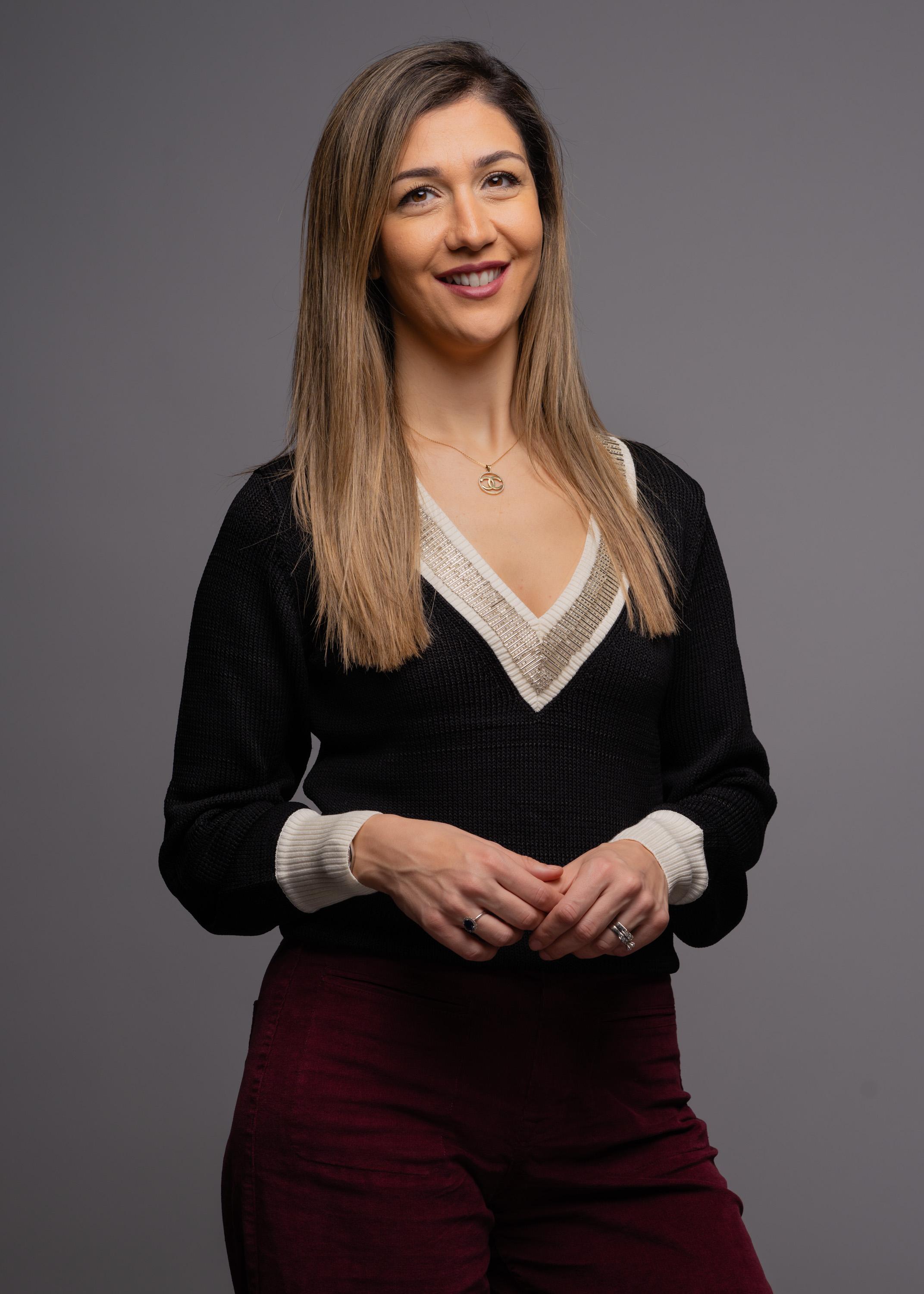 A woman in a business suit standing with her arms crossed