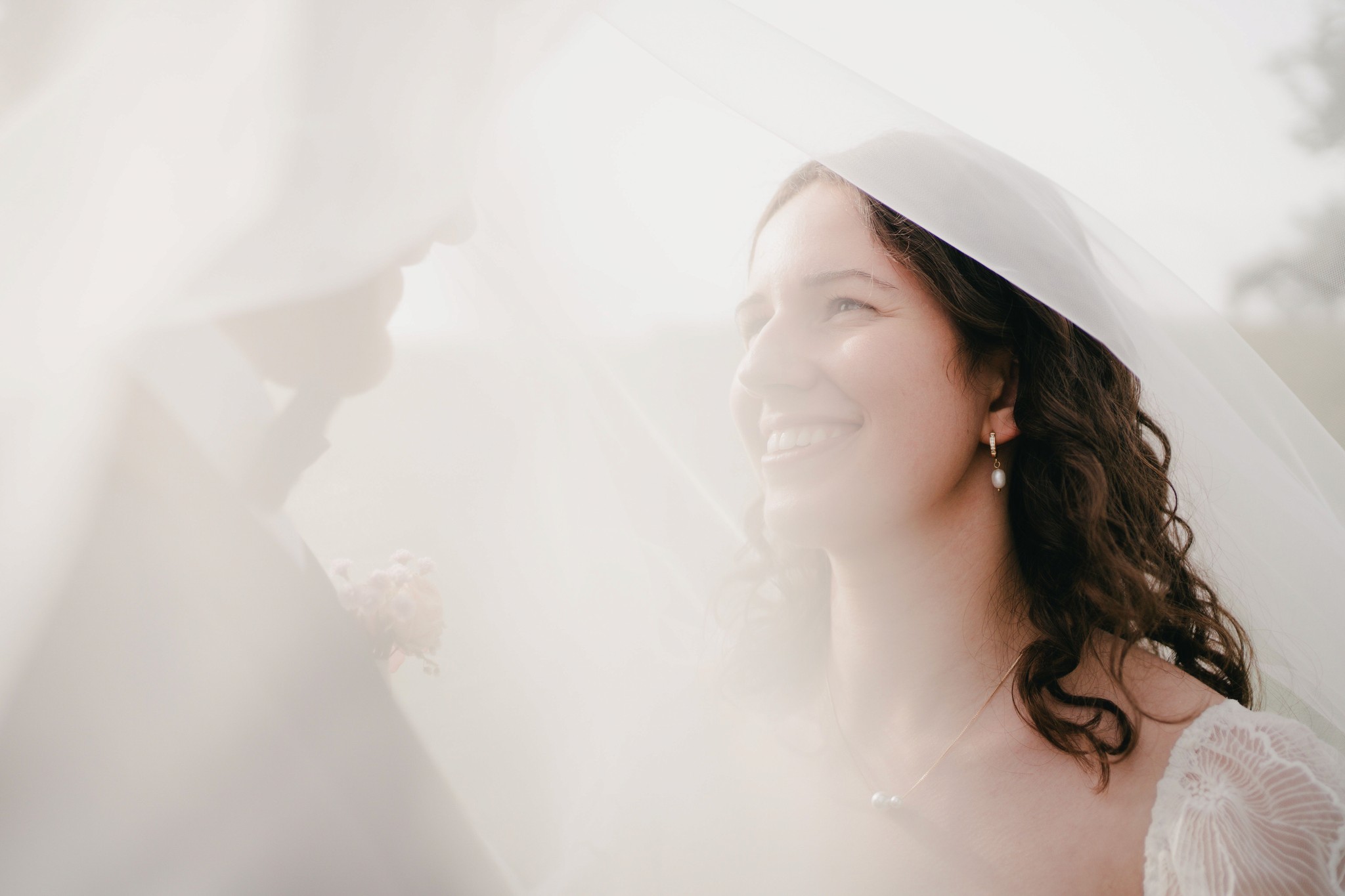 Ein nahes, ungestelltes Porträt einer lächelnden Braut unter ihrem Schleier – authentische Hochzeitsfotografie von Joshua Humpfer in Rothenburg o.d.T.