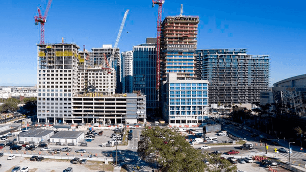 Interior view of Airside D terminal showing seating areas, passengers, and modern retail storefronts