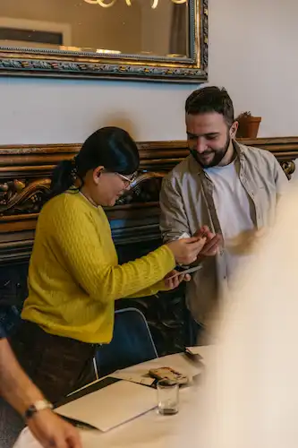 Two people sitting at a table and looking closely together.