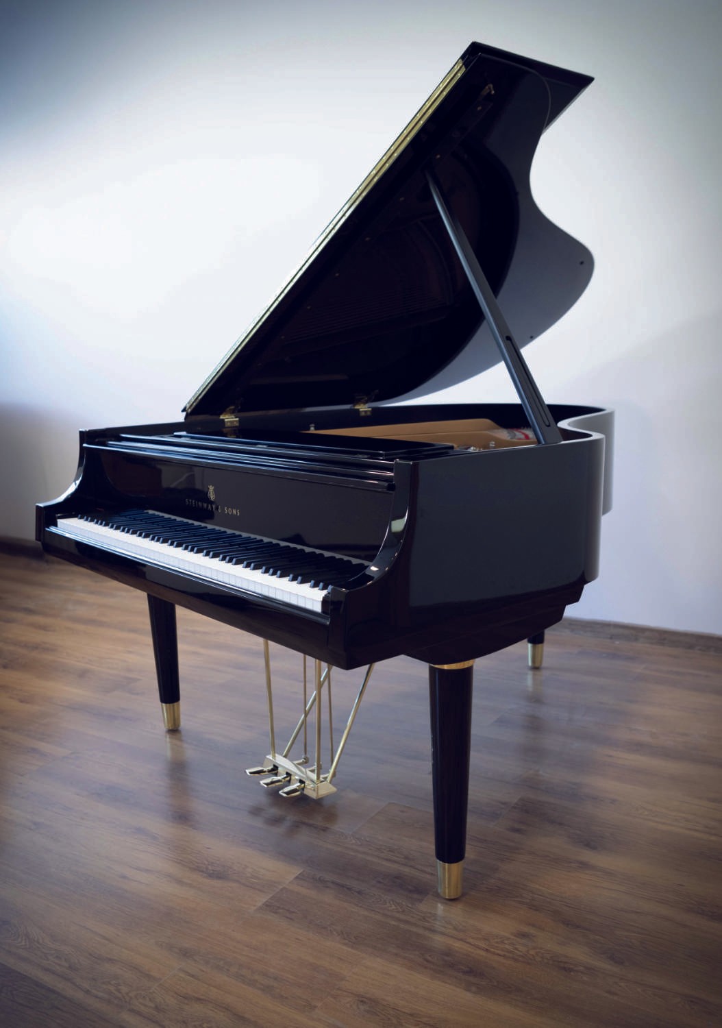 A full view of the Teague Model Steinway & Sons grand piano, highlighting its sleek black finish and modern elegance.