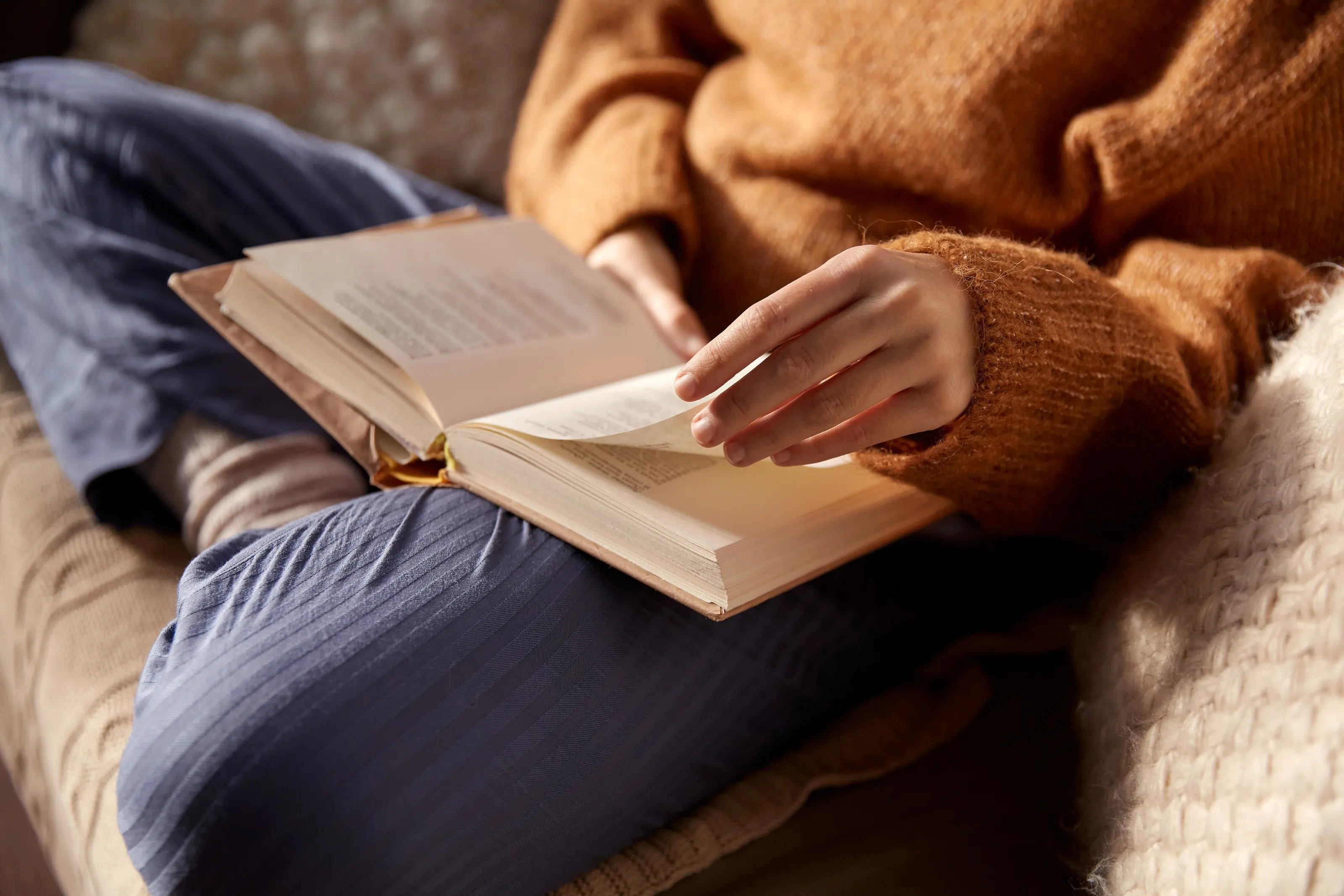 Resident relaxing and reading a book in the landscaped courtyard at Cocoon 121.