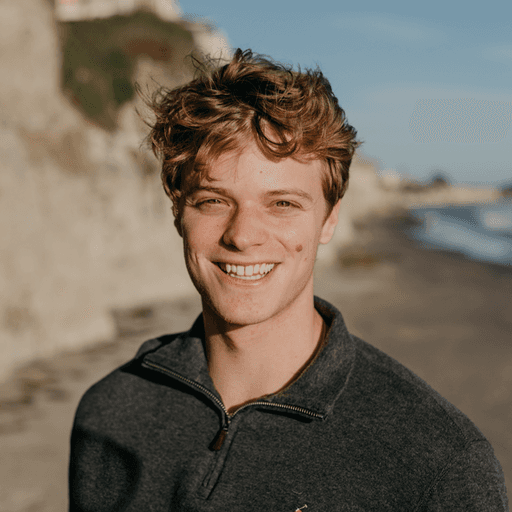 Photo of a smiling person standing on a beach