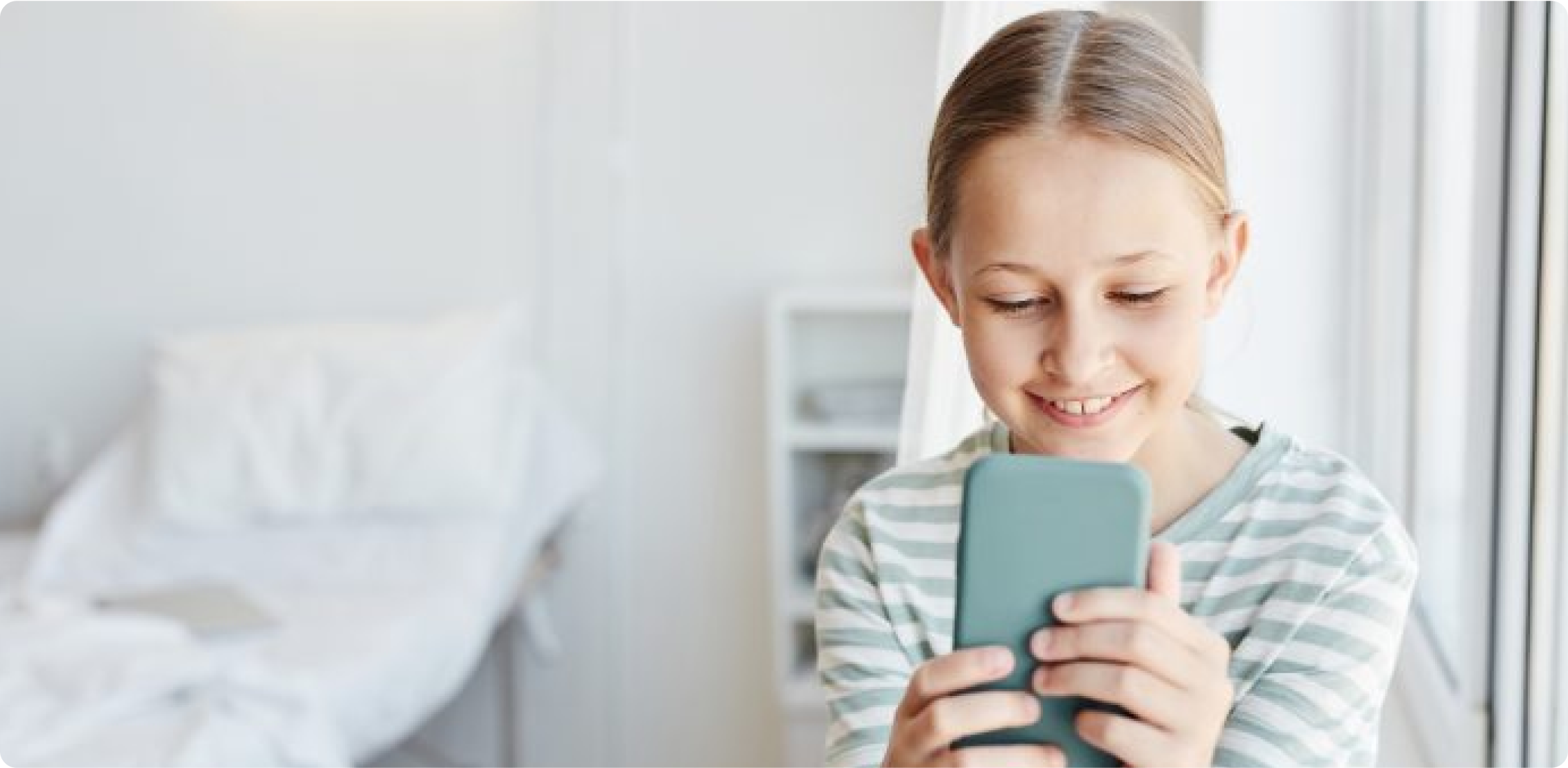Young girl using a mobile device and smiling