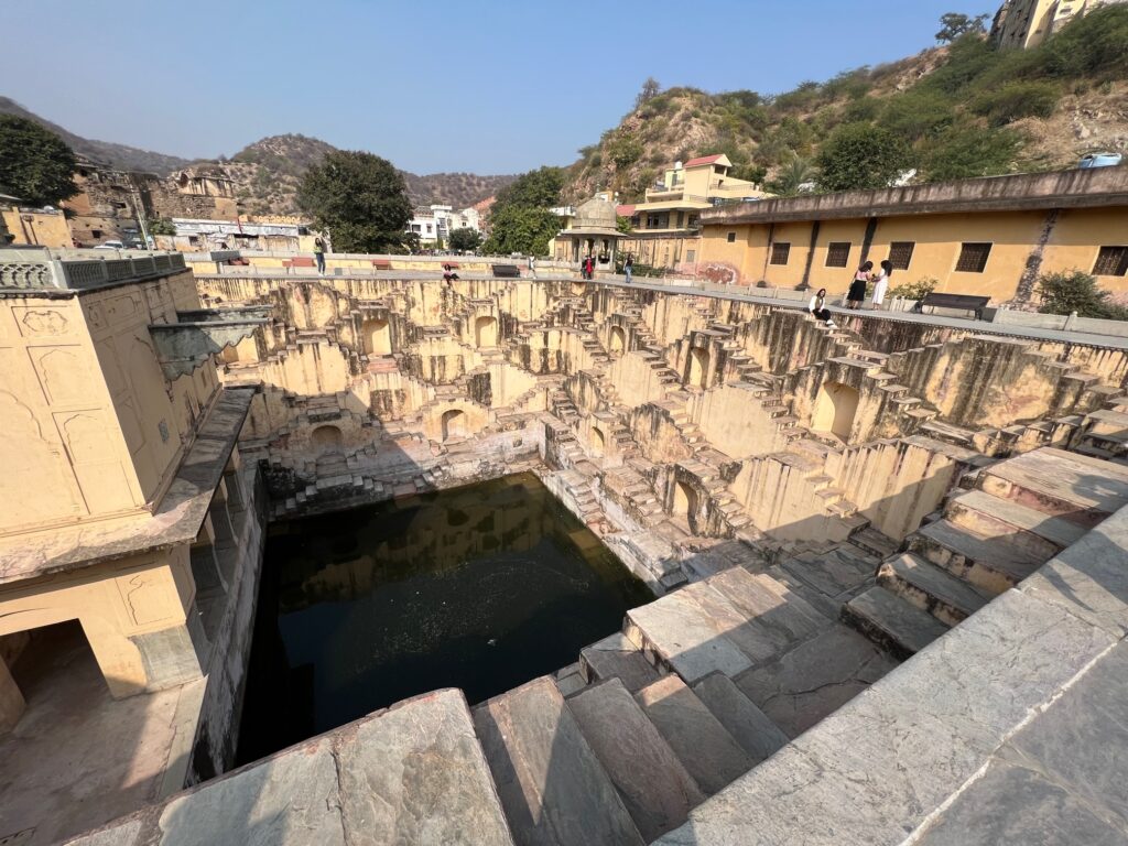 Panna Meena Ka Kund in its entirety against the backdrop of mountains and the town of Amer.