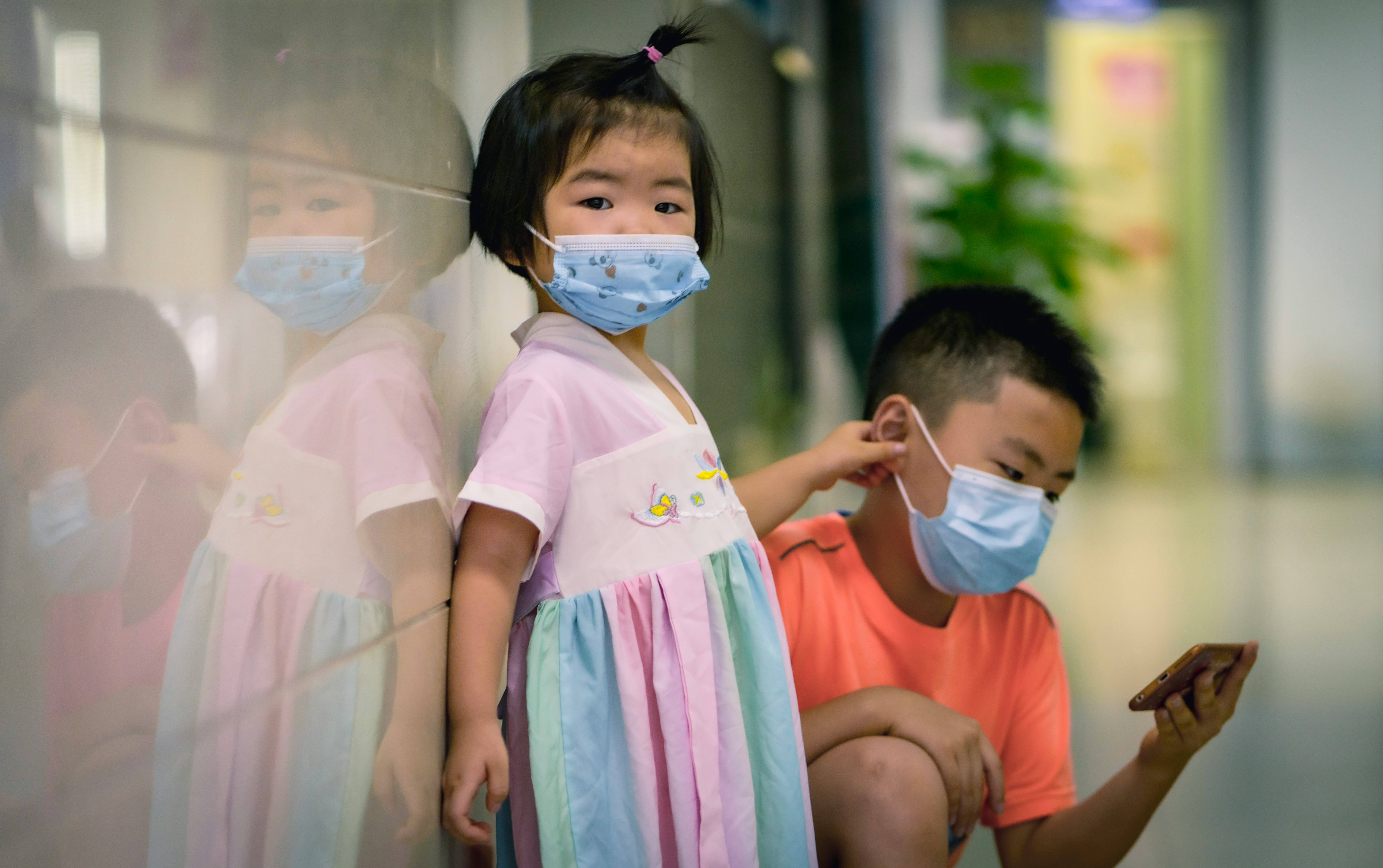 girl in white and pink dress with face mask