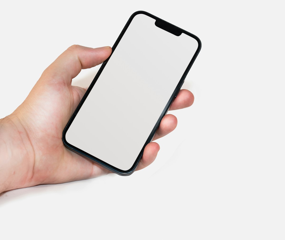 Hand holding a smartphone with a blank screen