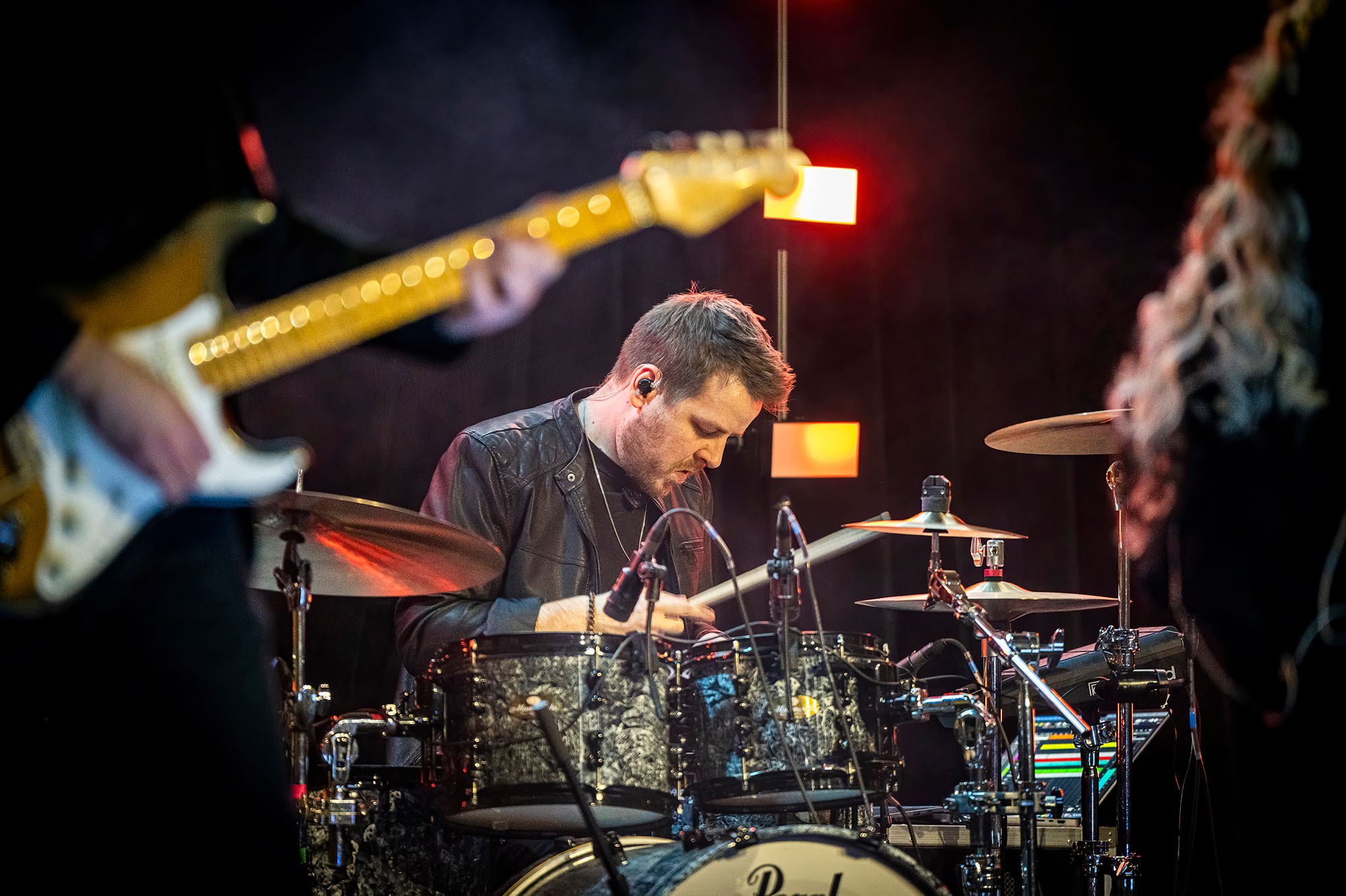 Live band performance during the evening programme at the CWS sales kickoff conference, with drummer playing on stage under concert lighting.