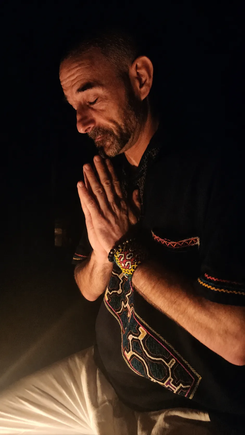 Retreat facilitator in quiet reflection with his hands together