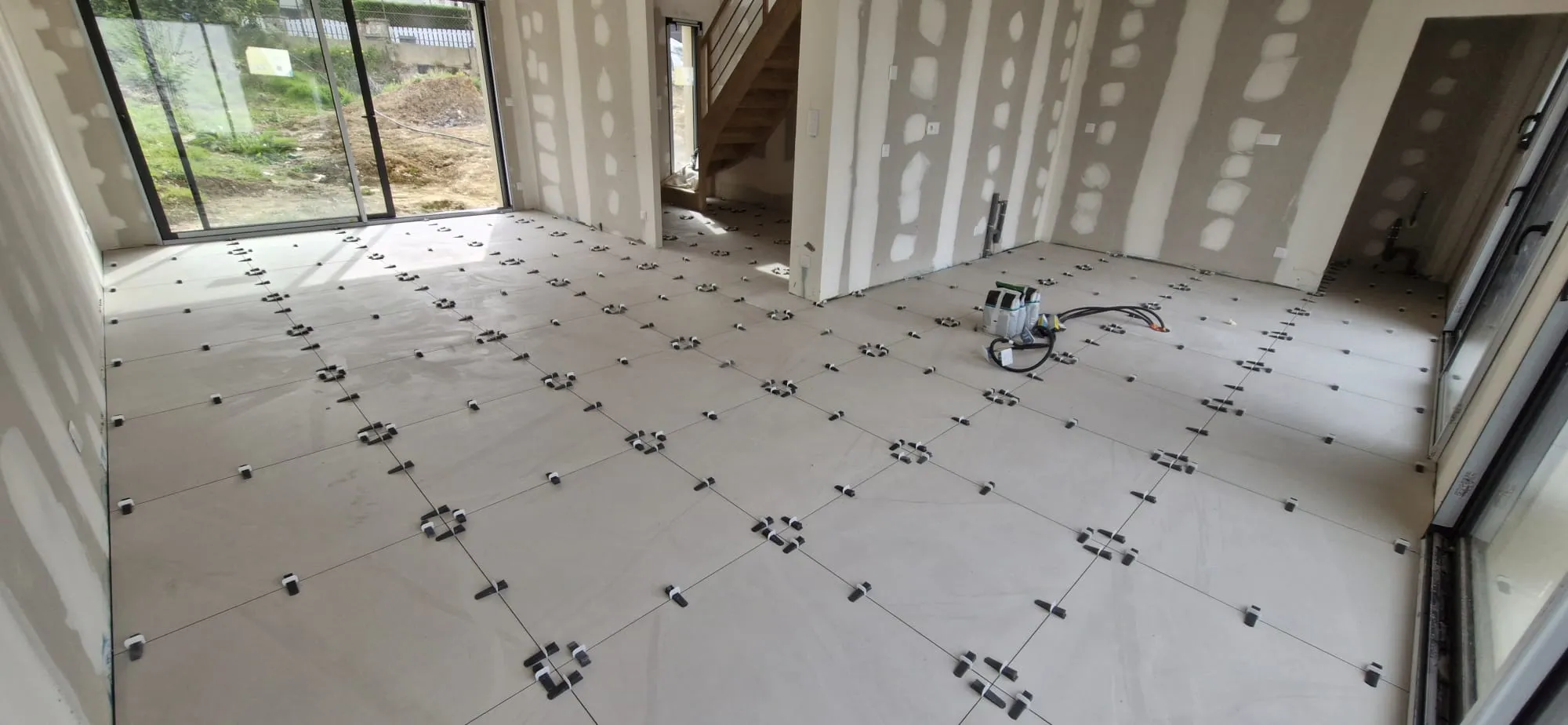 Pièce de vie en cours : carrelage grand format posé avec croisillons autonivelants