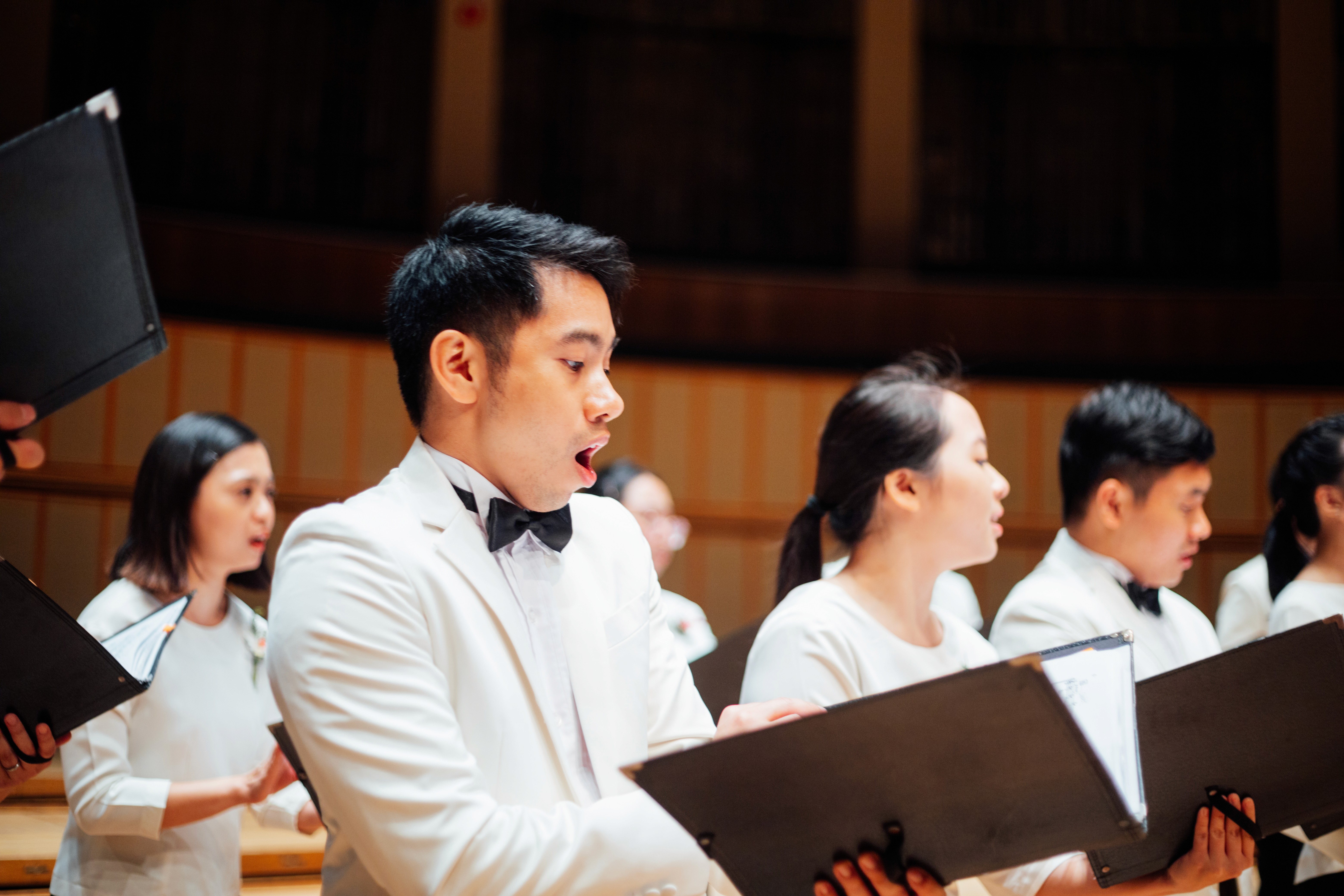 Close-up of a male ACJC choir member singing passionately during the performance at Esplanade Singapore.