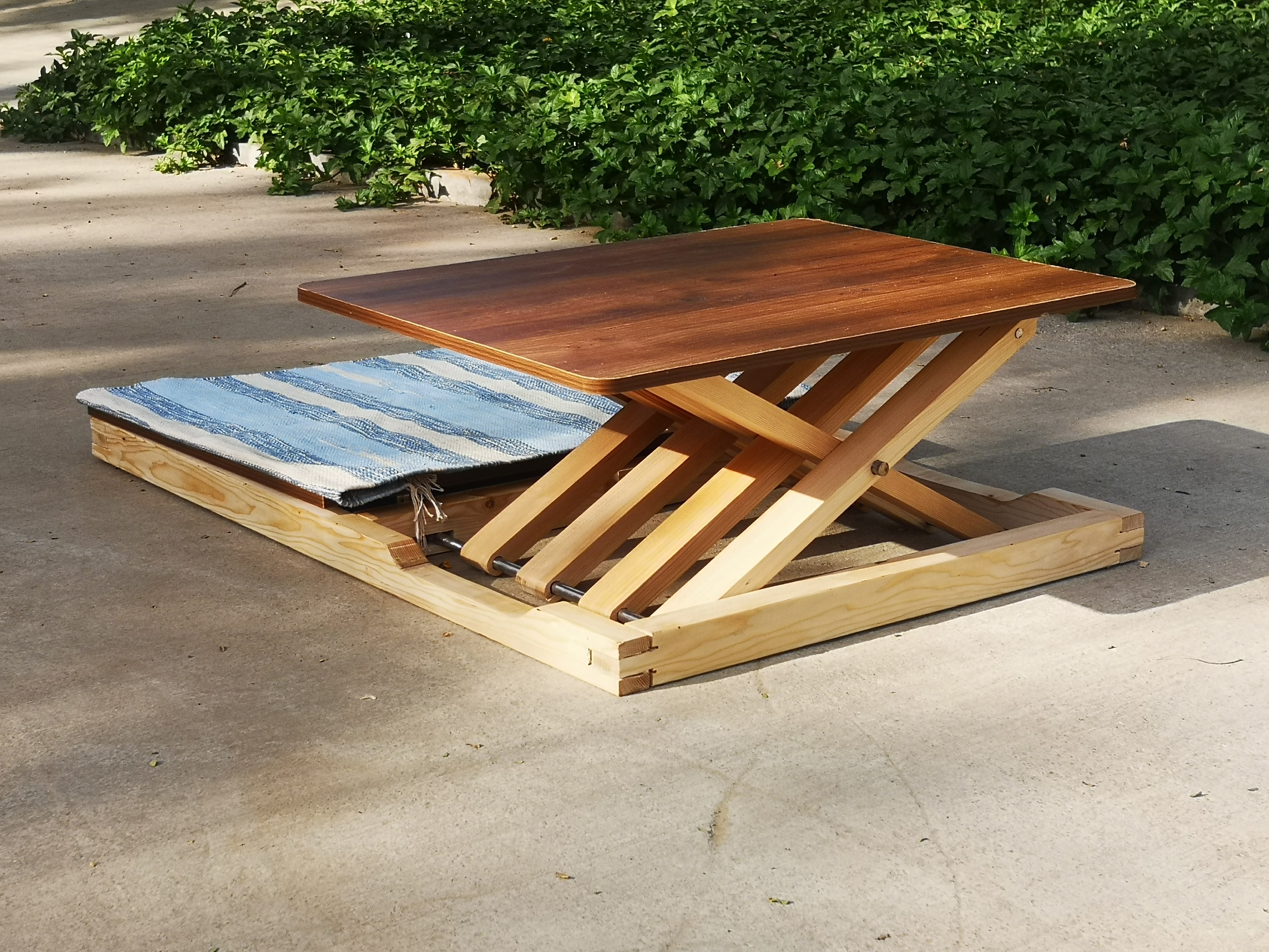 Brick waterfront building with large glass windows, reflecting the warm glow of a sunset over the river.