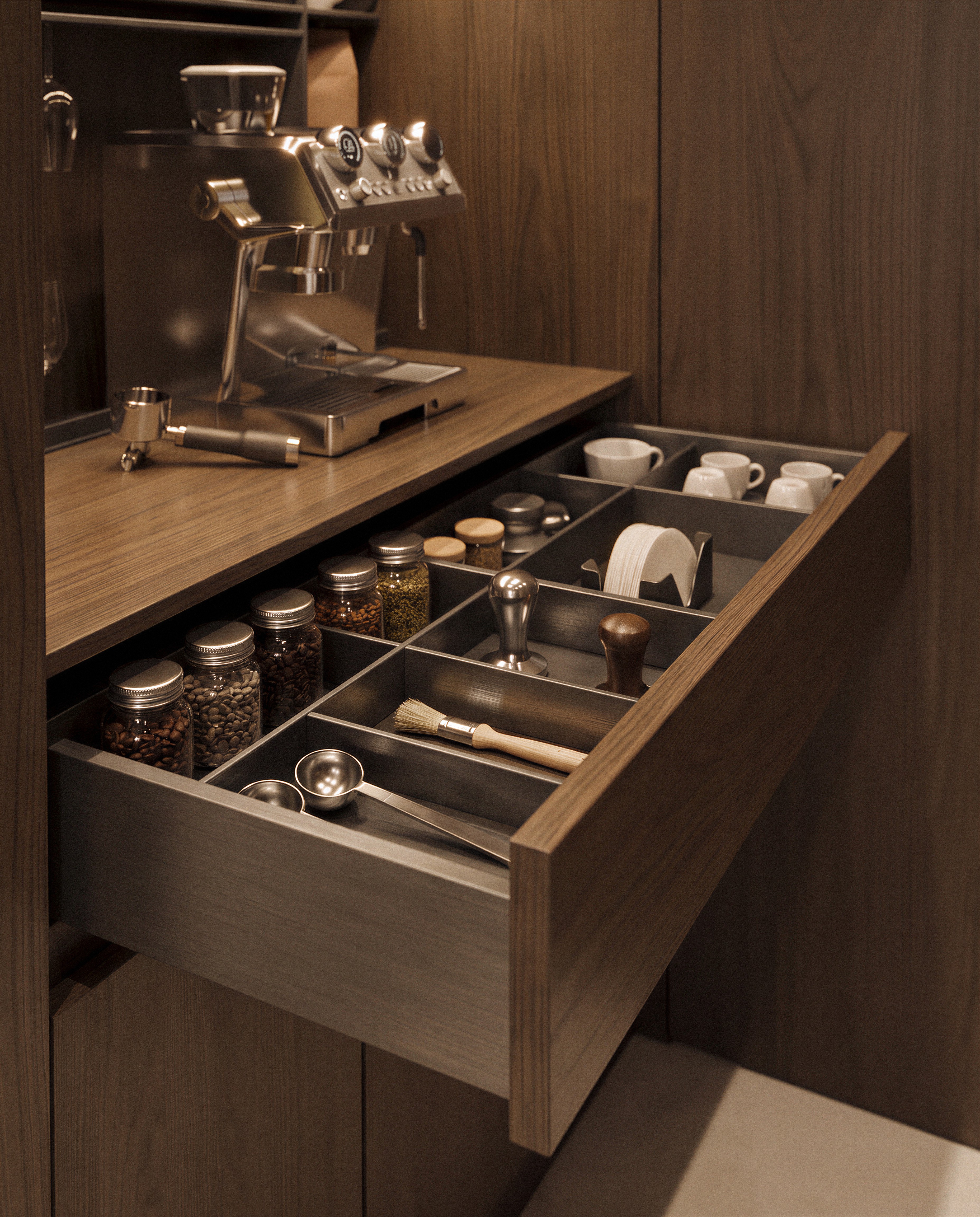 Custom walnut coffee station with an organized drawer insert for espresso tools, coffee beans, cups, and accessories in a bespoke cabinetry design.