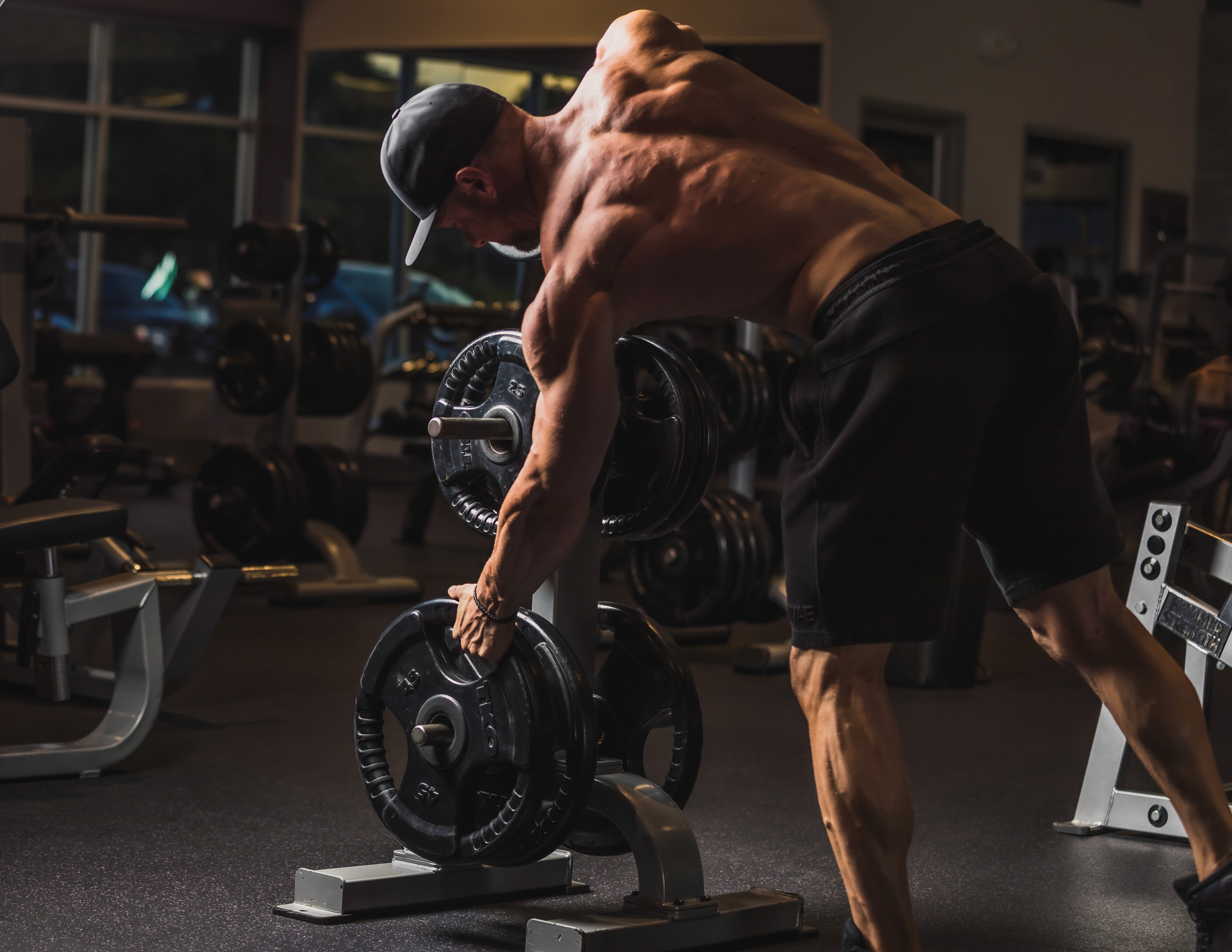 Jeremy Lankford lifting a weight plate during a gym session — long-term Chasing Gains online coaching client