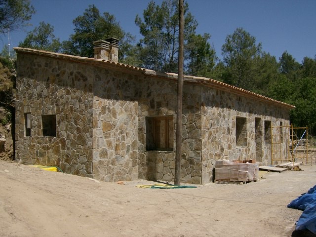 A modern brick house with a two-car garage, well-manicured lawn, and clear blue sky in the background.