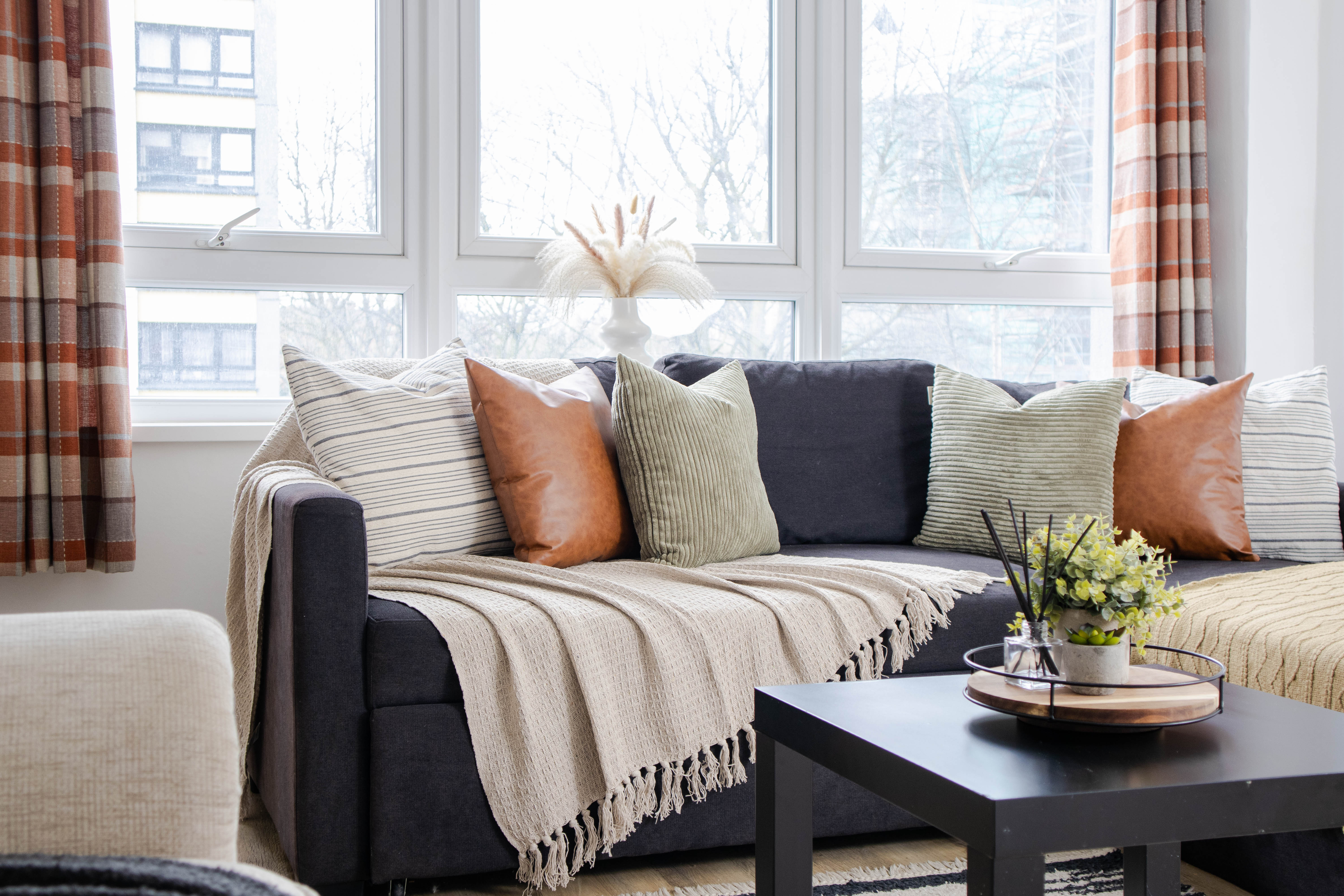 Airbnb photography of neutral toned throws and earthy coloured cushions