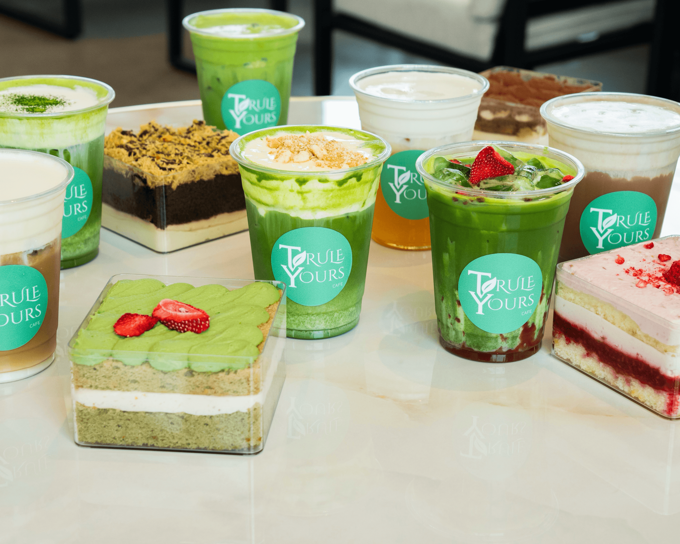 A group display of matcha cups and cake desserts at Trule Yours Cafe in Seattle