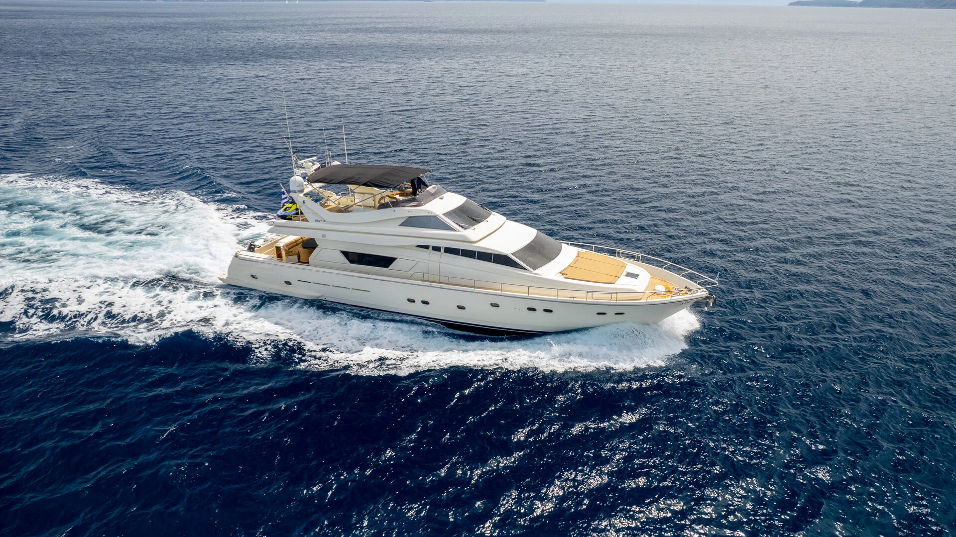 White Rock 36 speedboat with captain at helm cruising calm blue waters near Paros coastline with hills in background.