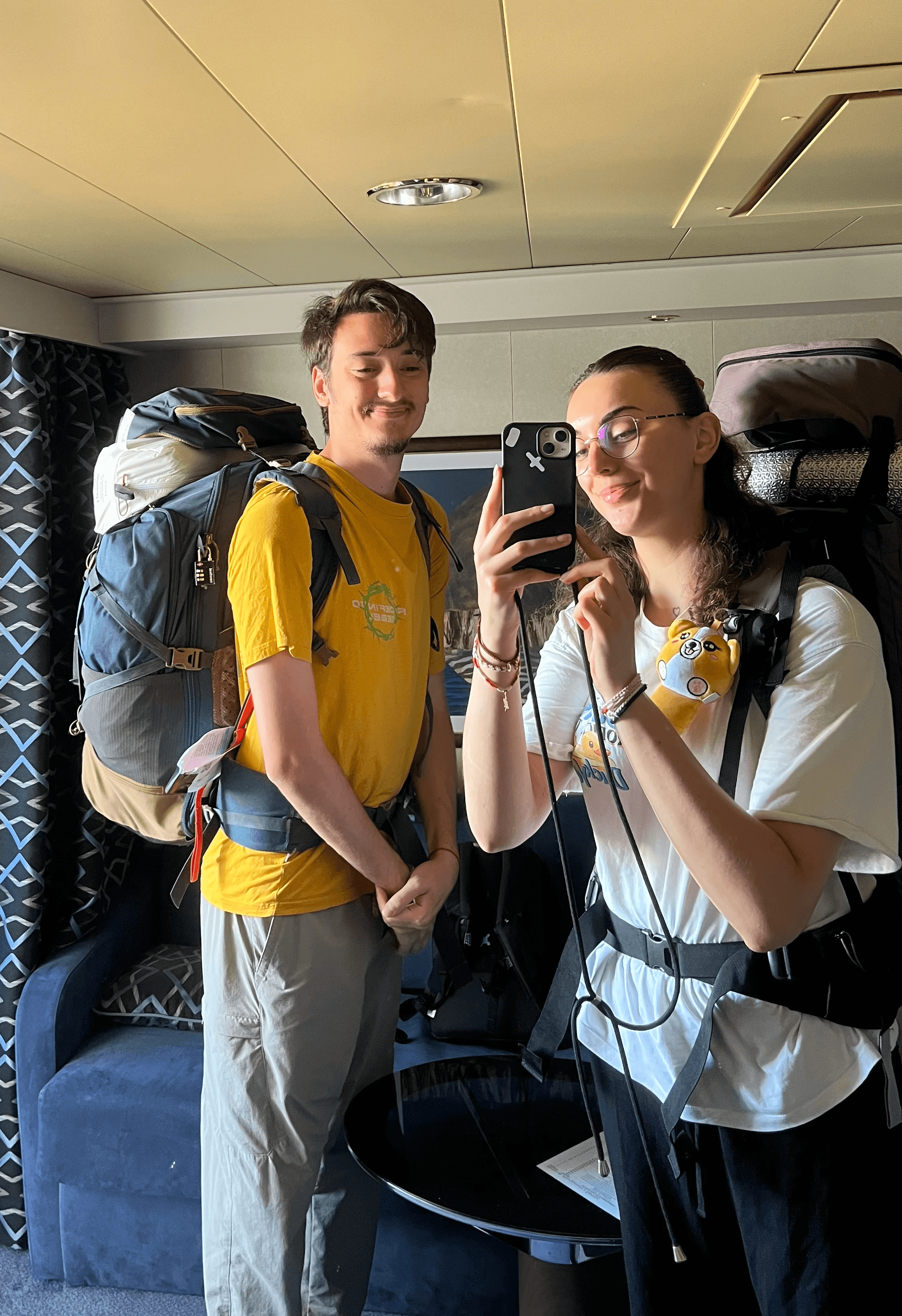 Tristan et Mathilde avec leurs sacs à dos dans une cabine de bateau