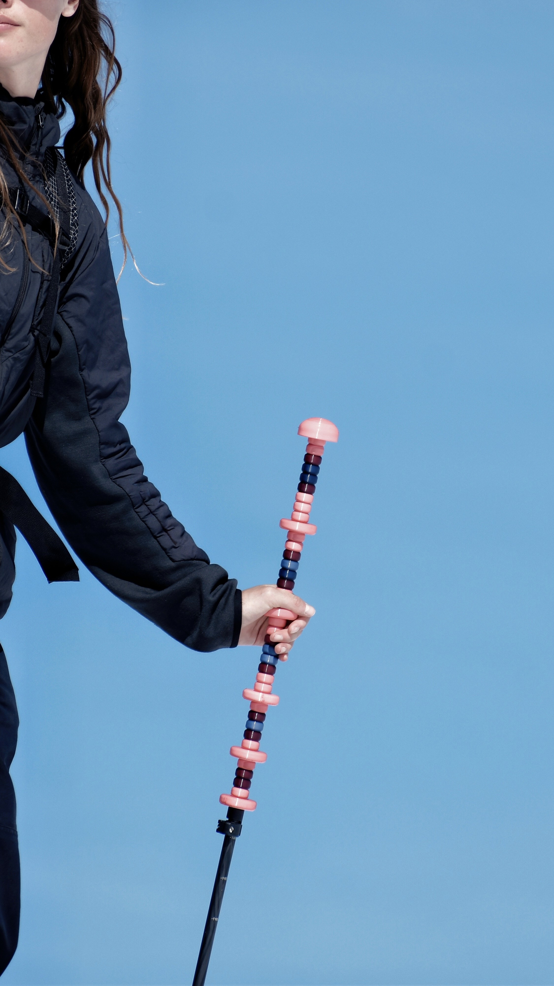 twIIgs push ledge backcountry ski poles held by skier in black jacket against blue sky