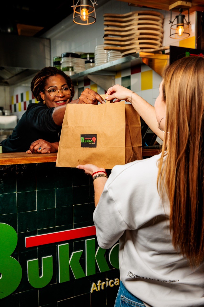 woman receiving order at a take out shop