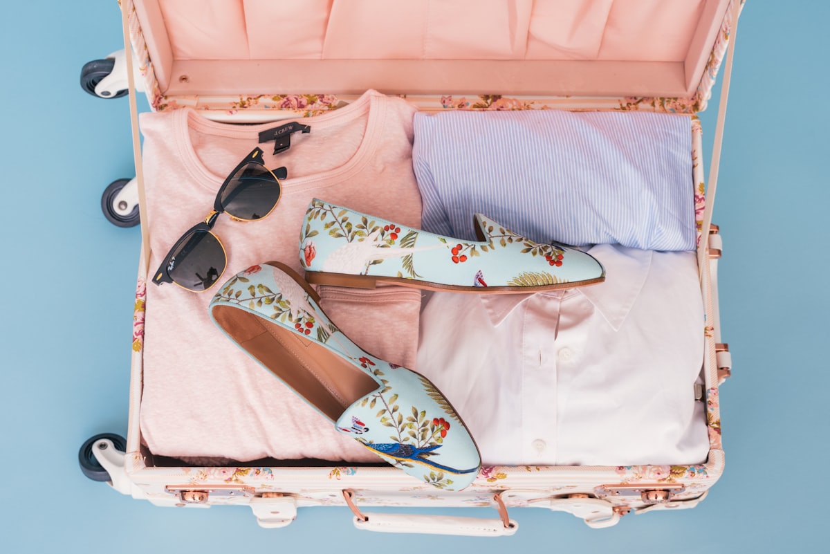 Packed suitcase with folded clothes and shoes, ready for a family summer vacation departure