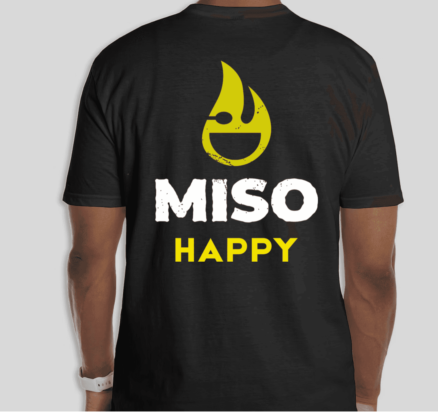 Black t-shirt with yellow Miso Healthy Icon and white Miso Happy text on a gray background