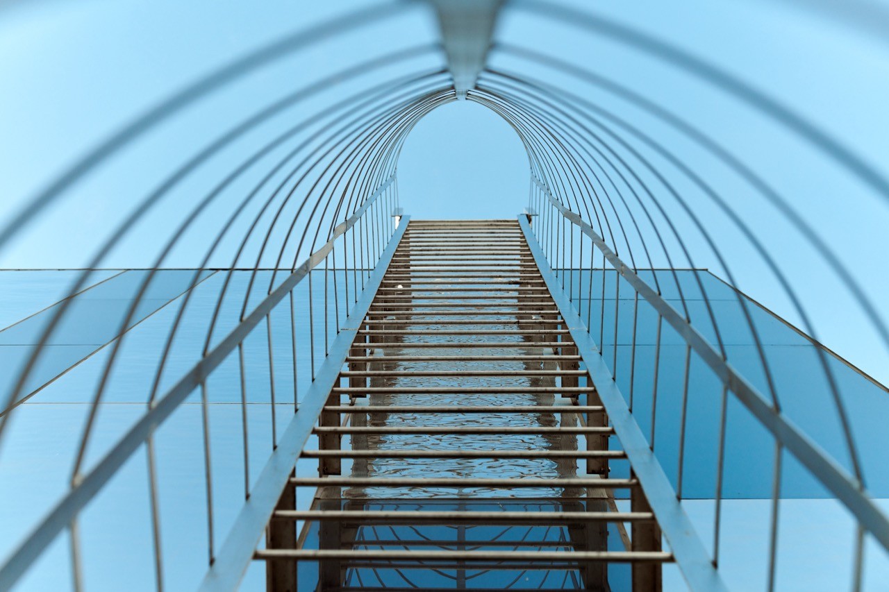 Architectural image of a modern staircase ascending within a structured, airy tunnel, symbolizing the progressive career opportunities at SAA Law Firm.