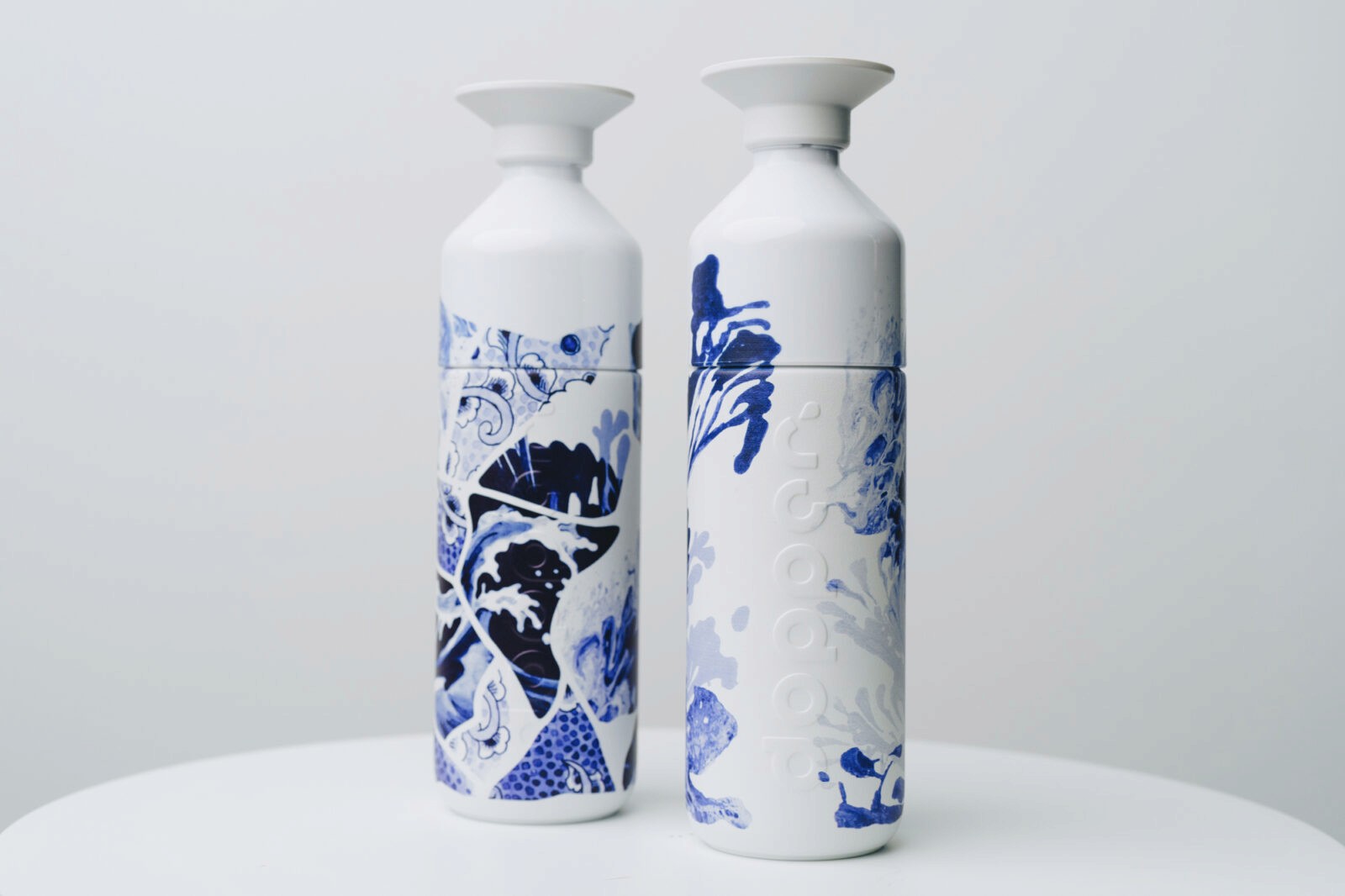 The image features two Dopper bottles with Royal Delft blue design