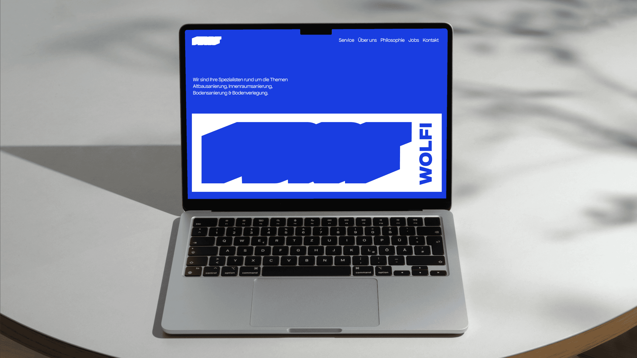 A black and white photo of a person with long hair leaning over a surfboard. The focus is on the arms and hands of the person resting on the board.