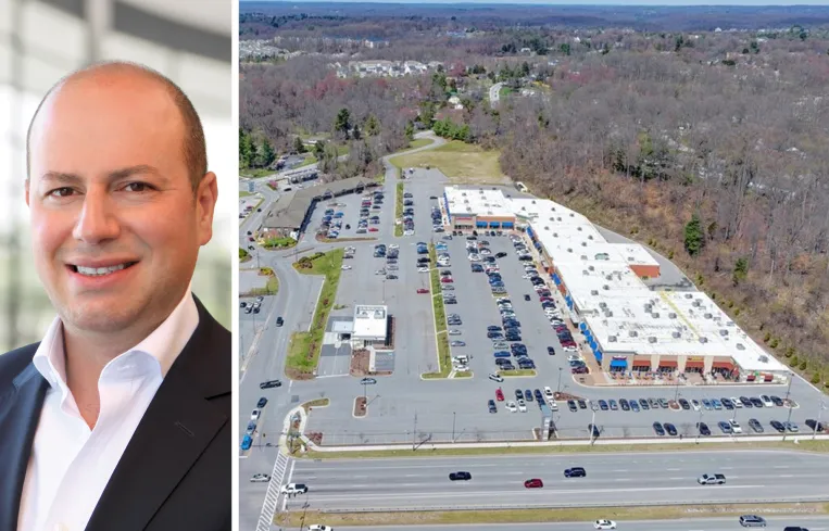 Tall modern skyscraper with vertical lines, viewed against a clear blue sky.