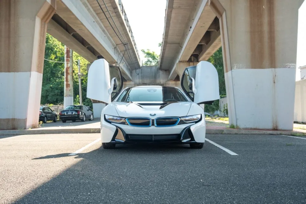 Head-on view of the BMW i8 under Miami’s elevated train tracks, emphasizing the car’s wide stance and aggressive front end.