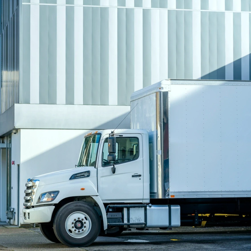 White box truck parked at a loading dock — commercial box truck insurance.