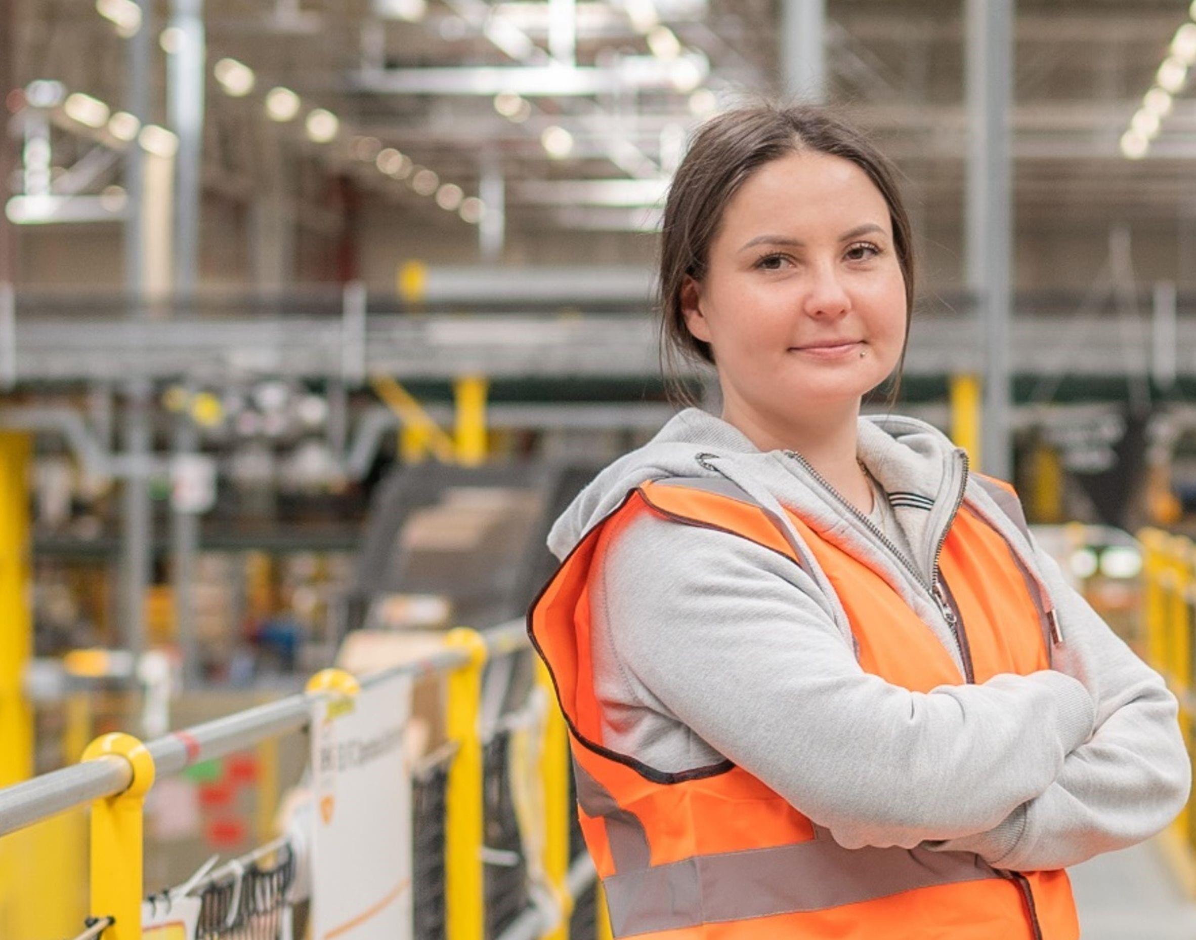 Amazon logistics warehouse employee in safety vest showcasing positive workplace environment and professional dignity in modern fulfillment center - employer branding repositioning and crisis communication strategy following negative media coverage, managed by Alessandro Brancati Marketing & Growth Studio via Adecco partnership to rebuild trust and attract warehouse talent in Italian market