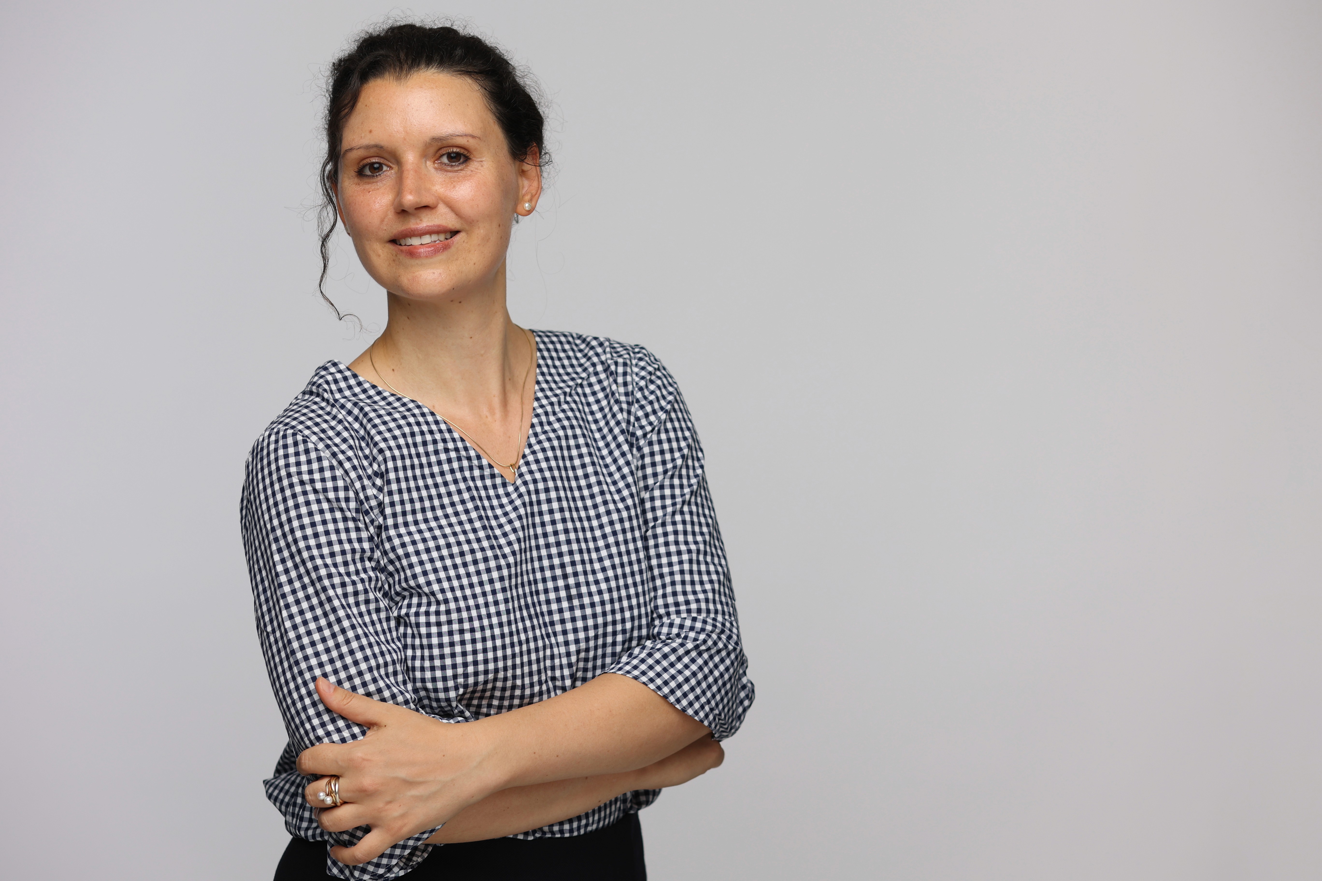 woman in blue tank top standing beside white wall
