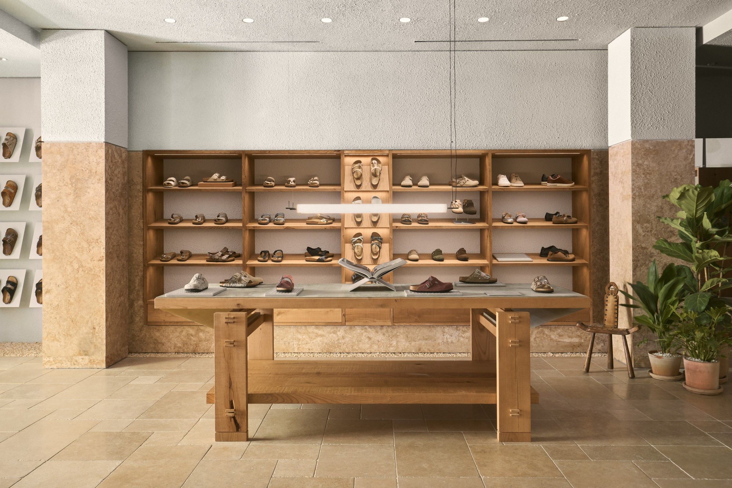 Birkenstock footwear displayed on a custom wooden table and shelving at the Claudio Coello store in Madrid, designed by Matteo Ferrari.
